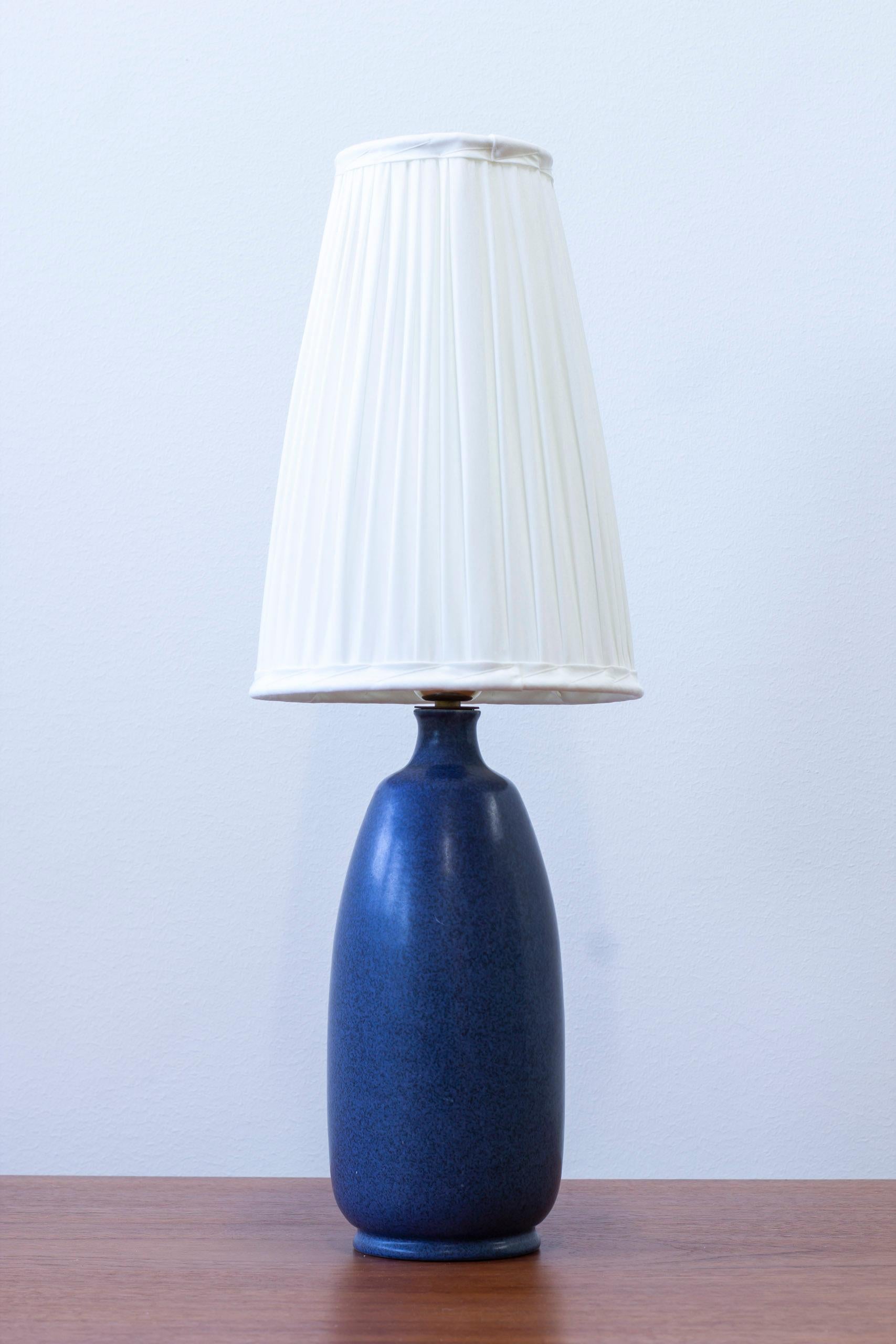 Lampe de table conçue par Eric och Ingrid Triller. Produit par la société Tobo en Suède dans les années 1940-50. Fabriqué en grès émaillé bleu. Douille en laiton et nouvel abat-jour en coton cousu à la main. Très bon état vintage avec une patine et
