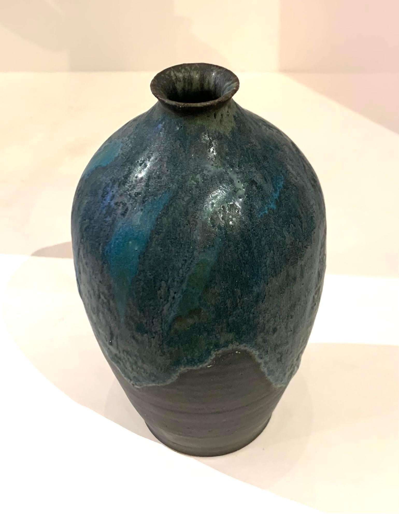 Contemporary American Ceramist Peter Speliopoulos stoneware vase.
One of many pieces from a large collection of work.
Sits nicely with S5828 thru S5835.
Signed by the artist.
The matte blue glaze, paired with an agate glaze, react to create