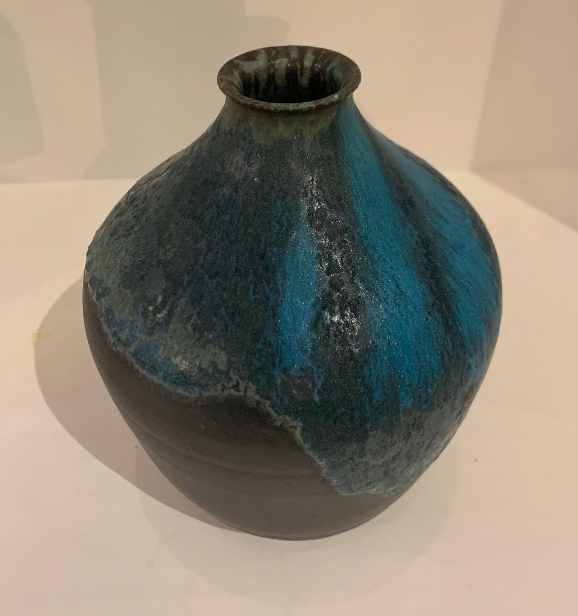 Contemporary American Ceramist Peter Speliopoulos stoneware vase.
One of many pieces from a large collection of work.
Sits nicely with S5828 thru S5835.
Signed by the artist.
The matte blue glaze, paired with an agate glaze, react to create