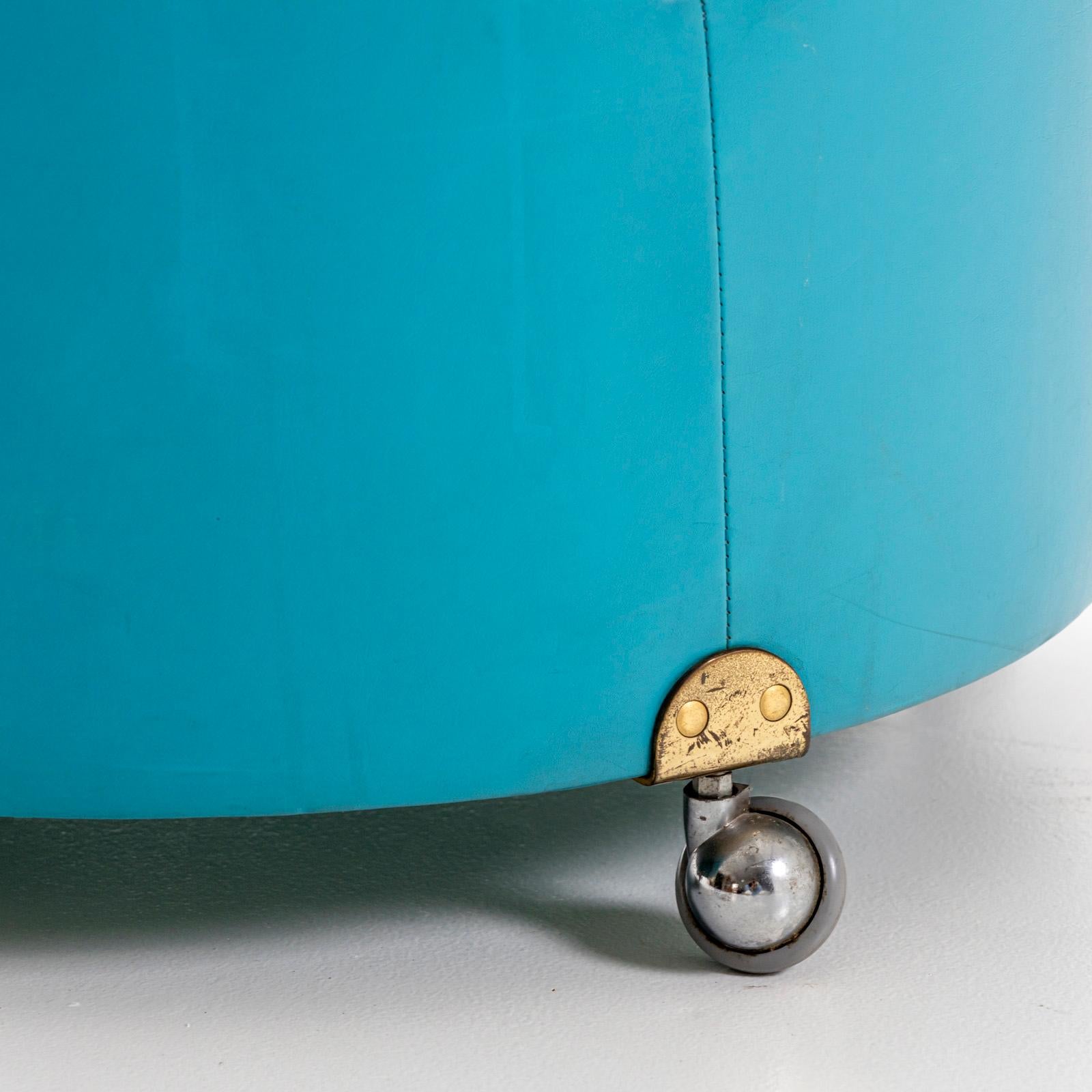Piccolo pouf blu chiaro con cuscino di seduta trapuntato e struttura a forma di botte con piccole rotelle. Il pouf è stato disegnato da Luigi Massoni & Massoni negli anni Settanta.