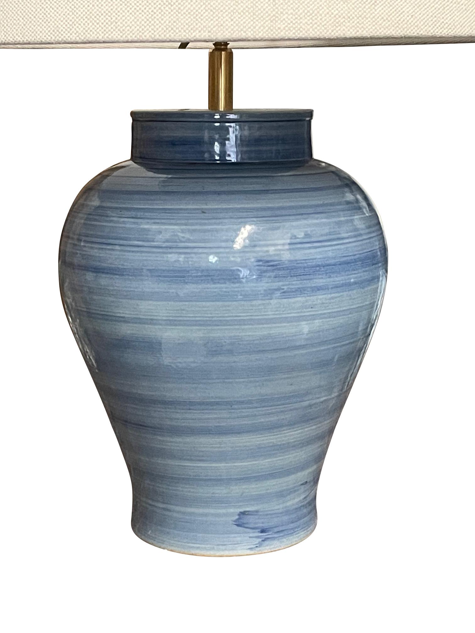 Contemporary Chinese single blue lamp with horizontal striated design.
Ginger jar shape design.
New Belgian linen shades
Newly wired
Overall height. 22