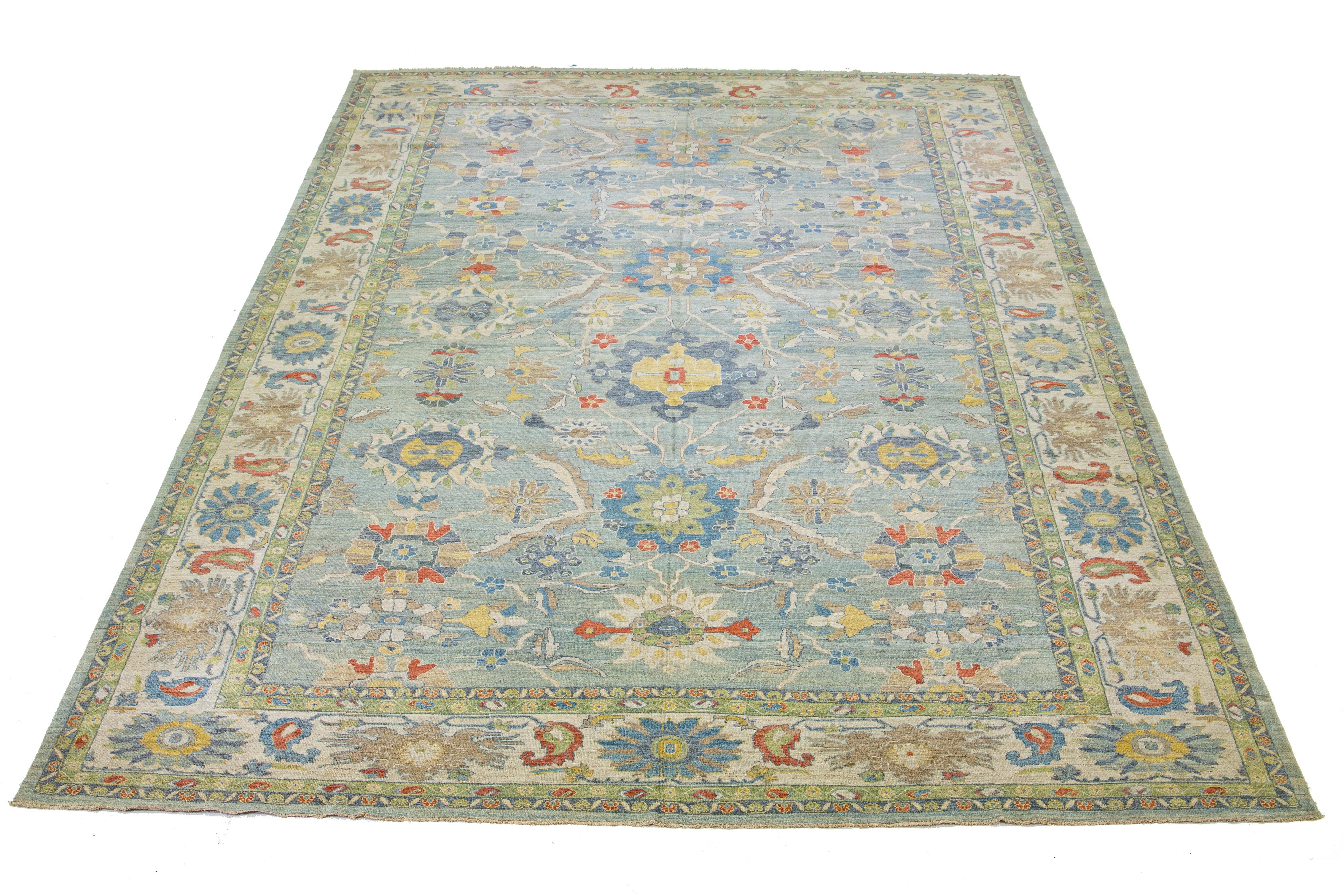 This oversized Sultanabad classic style has been meticulously transformed into a contemporary masterpiece. This magnificent wool rug has a light blue field. It has A beige frame with an all-over floral motif. To enhance its elegance, it incorporates
