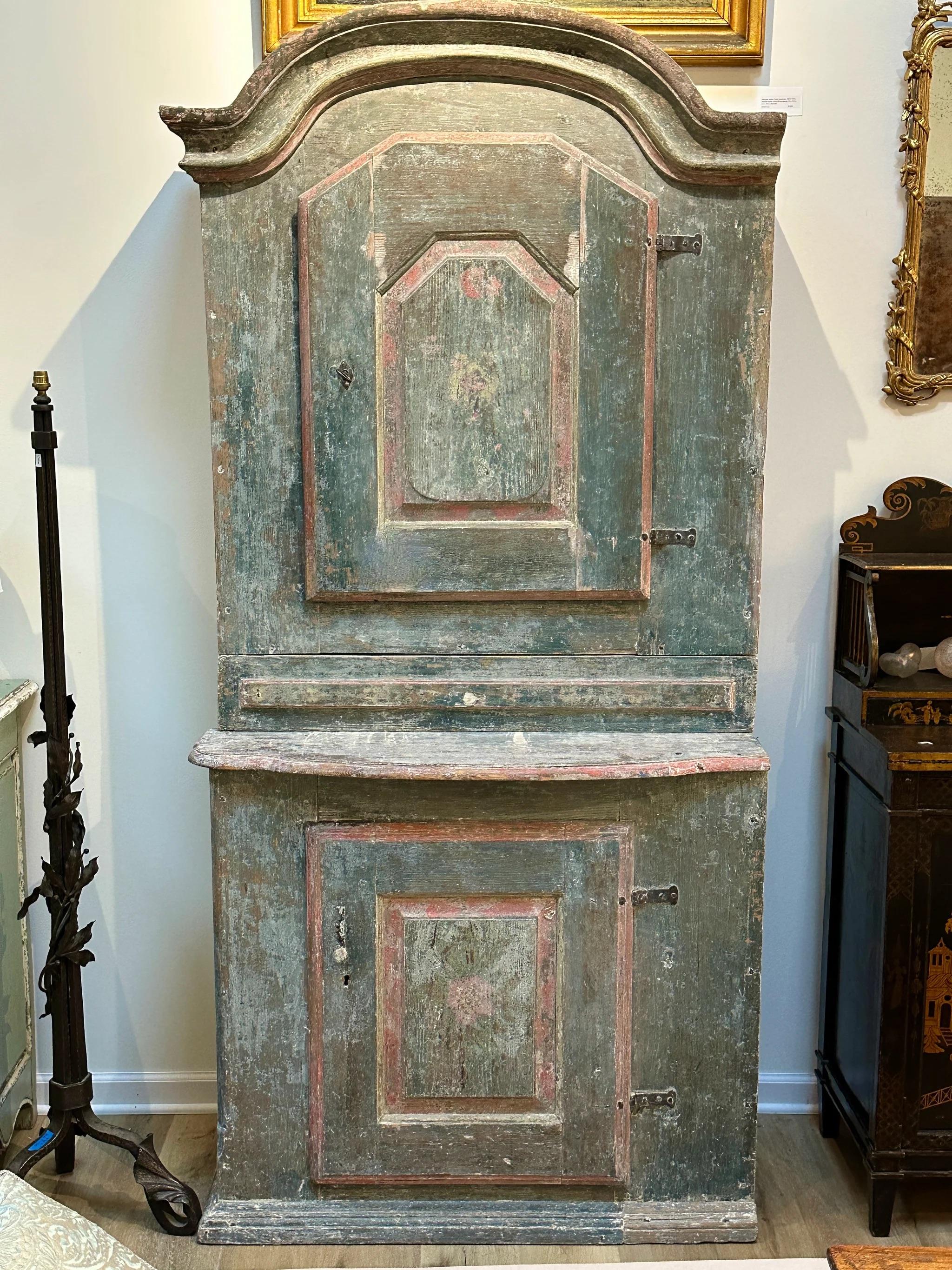 Swedish Cabinet, c. 1800, likely Dalarna, having original blue paint (scraped down from later paint).  A deeply carved cornice over a cabinet with a single door, having two interior shelves over one wide drawer over a lower cabinet also having