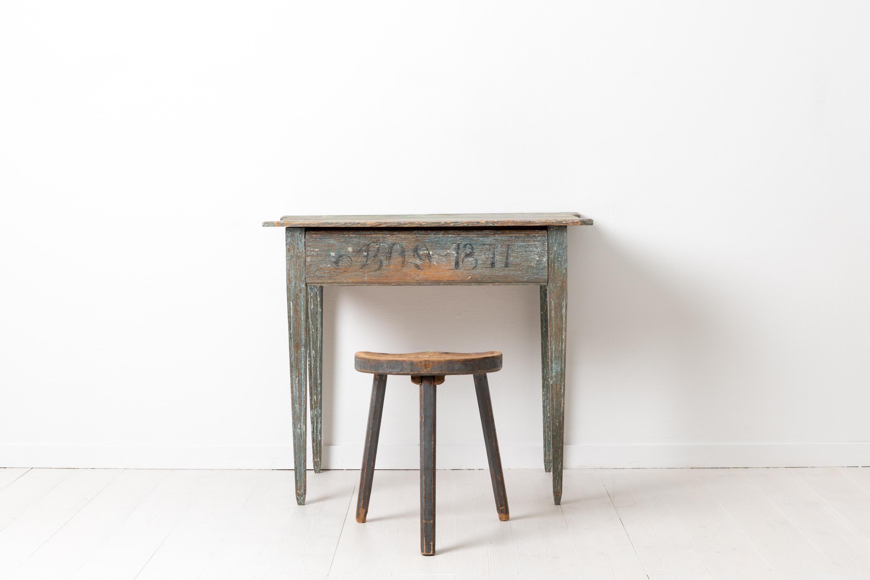 Gustavian wall table in painted pine with the original distressed paint. The table has straight tapered legs with vertical flutes. An unusual detail is the ending of the legs which are decorated with stylised crosses. Even the protruding corners of