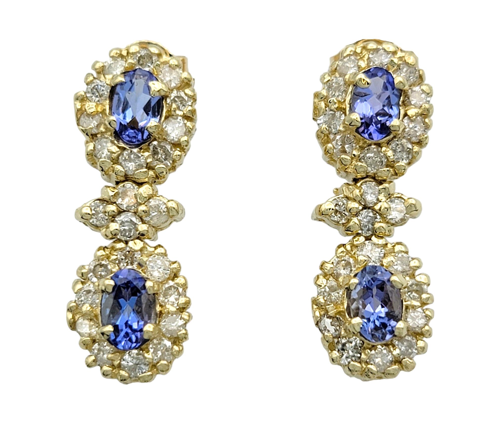 These captivating dangle earrings are a testament to elegance and sophistication, crafted to captivate attention with their mesmerizing beauty. Set in lustrous 14 karat yellow gold, each earring features two stunning oval tanzanites, boasting a