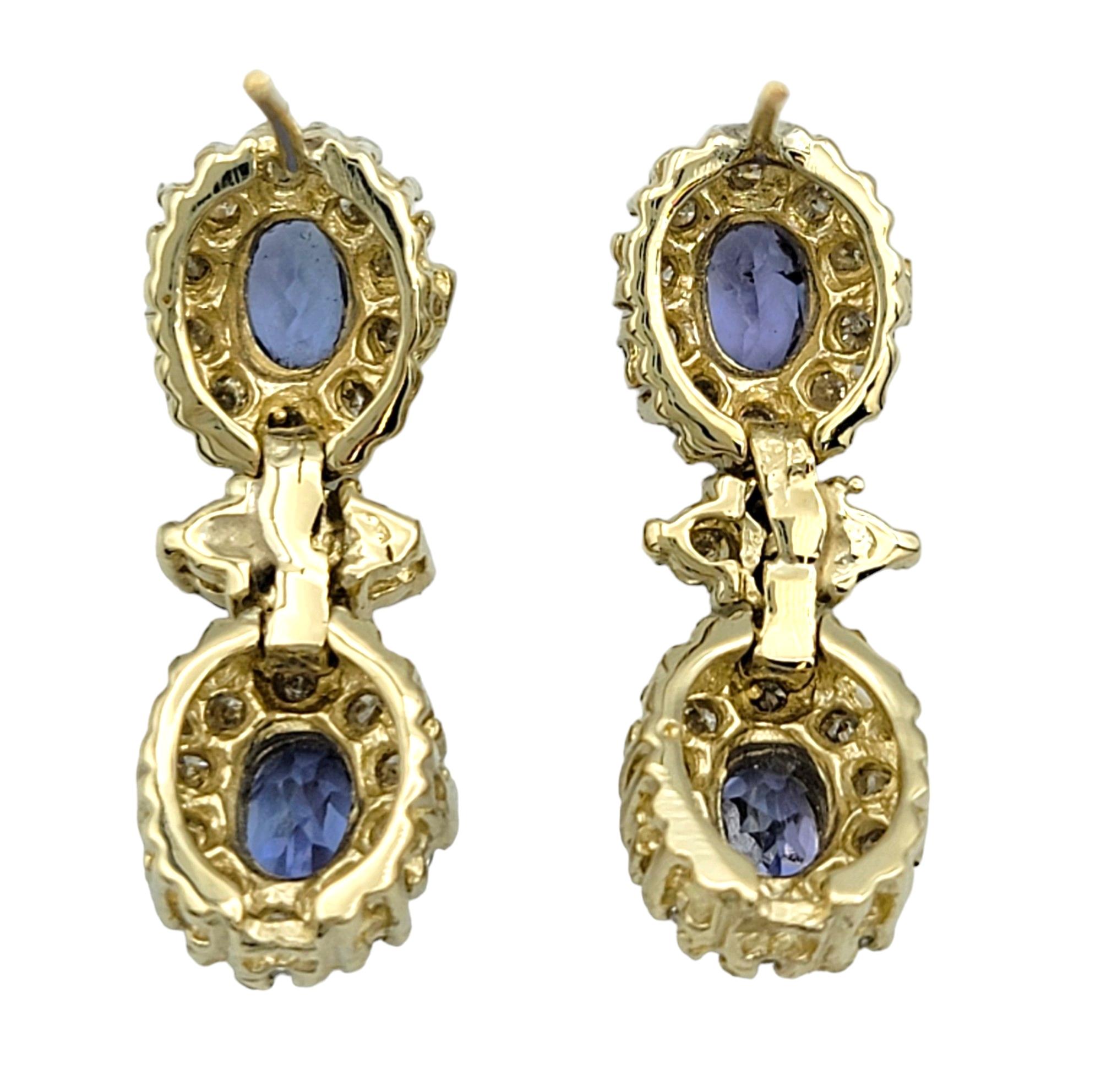 Oval Cut Blue Tanzanite and Diamond Halo Dangle Earrings Set in 14 Karat Yellow Gold For Sale