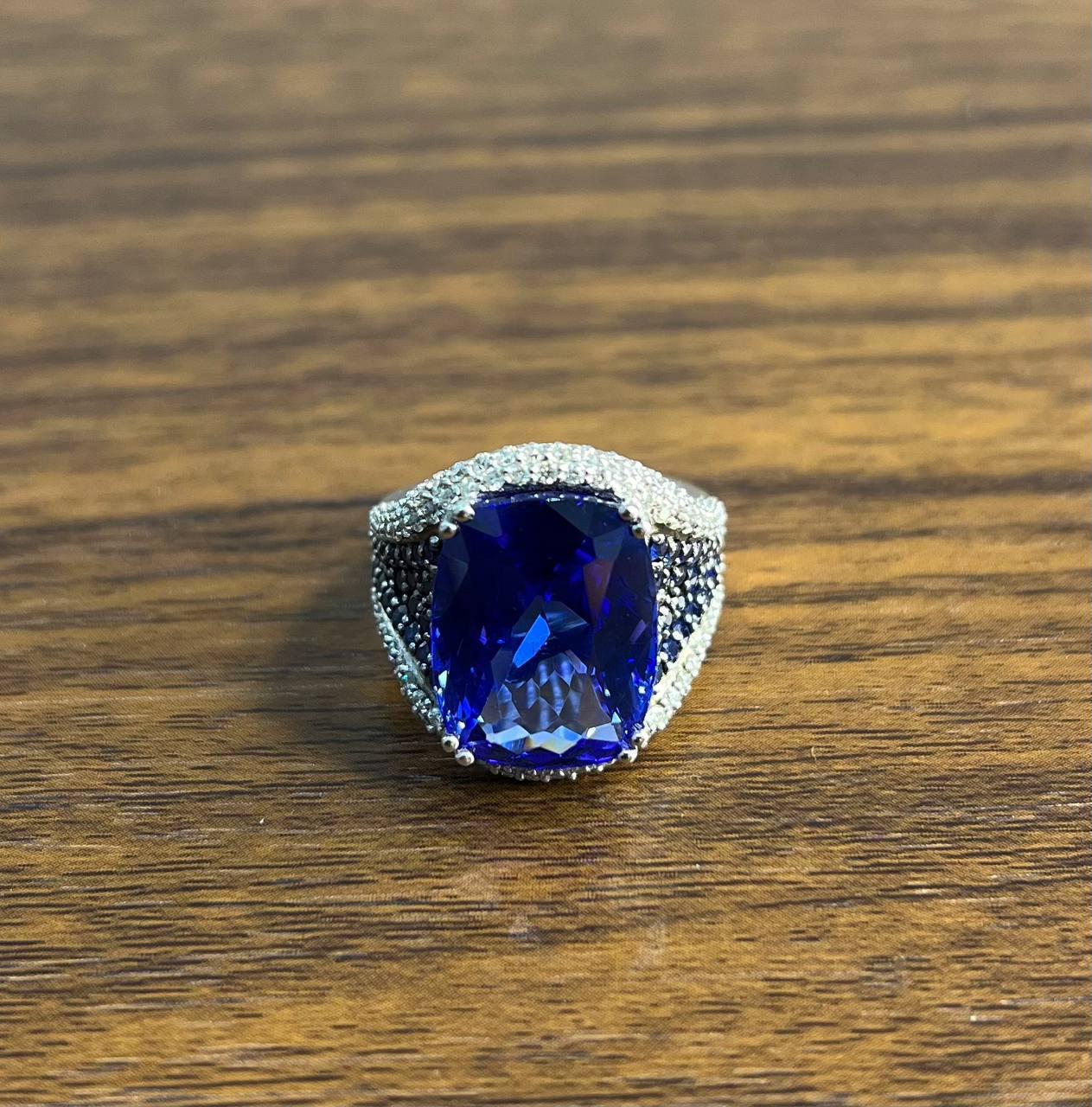 Cette pièce exquise présente une grande tanzanite d'un bleu profond, sertie d'un ensemble éblouissant de petits diamants étincelants. La pierre précieuse est solidement maintenue par quatre doubles griffes, ce qui permet à la lumière de rehausser sa