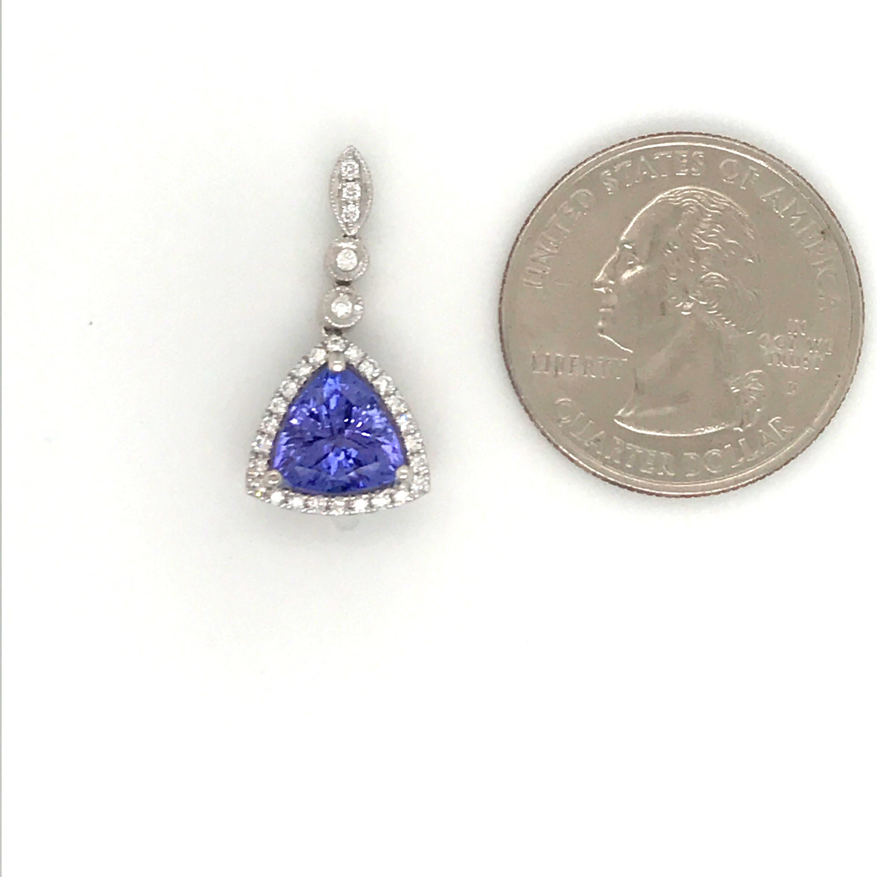 18K White gold pendant featuring one blue Tanzanite weighing 2.45 carats flanked with round brilliants weighing 0.23 carats. Comes with a 16 inch white gold chain. 
Color G
Clarity VS