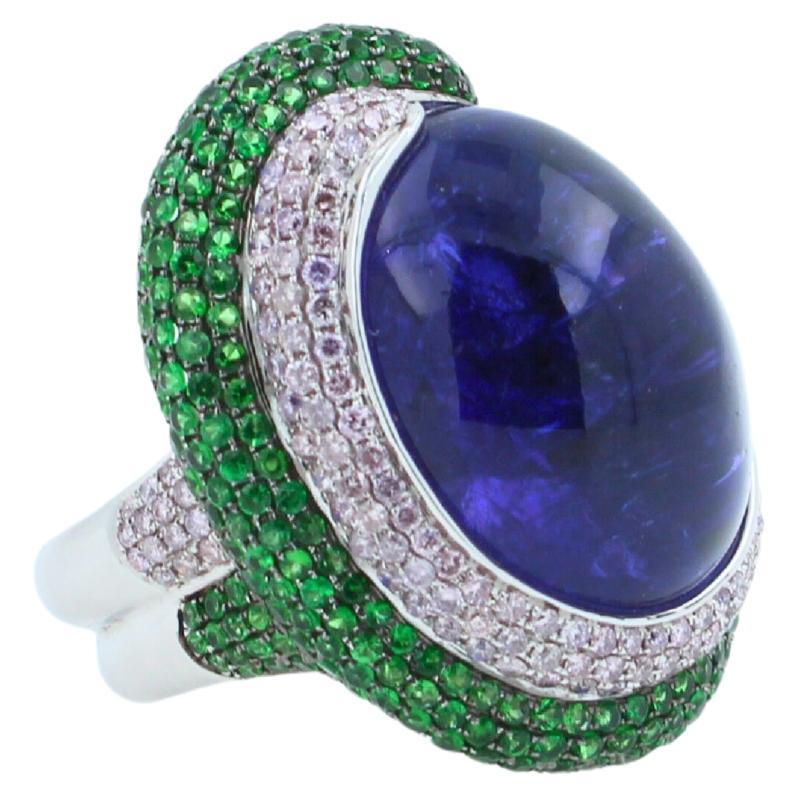 Tanzanite Oval Cabochon 50.00 Carats
Dark Sea Blue Color & Hues
Tsavorites 1.25 ctw
Diamonds 1.25 ctw
18K White Gold
26.80 grams
Ring Size 7
31.50 mm length of front ring
24.00 mm width of front ring
7.50 mm back shank width 