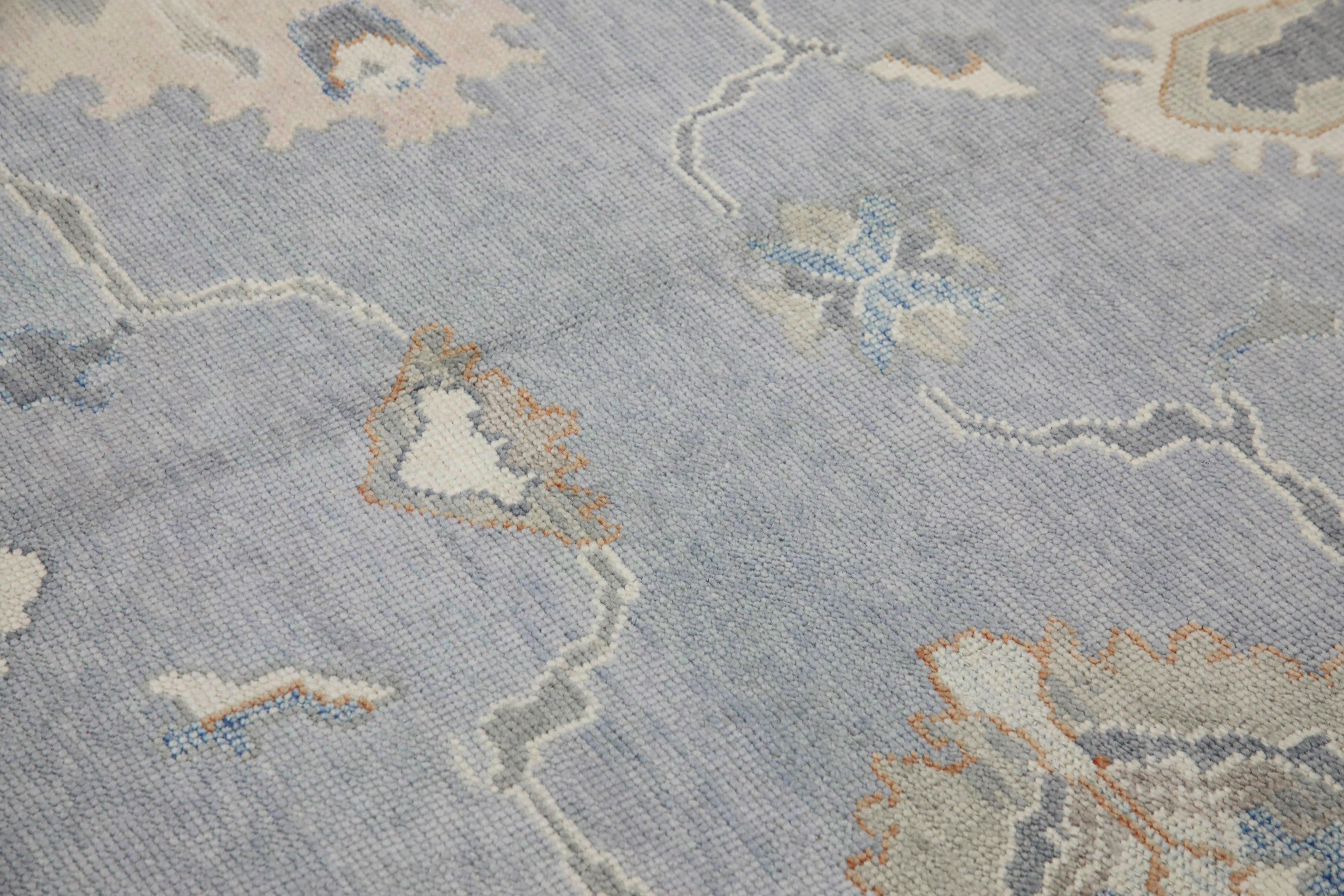 This modern Turkish Oushak rug is a stunning piece of art that has been handwoven using traditional techniques by skilled artisans. The rug features intricate patterns and a soft color palette that is achieved through the use of natural vegetable