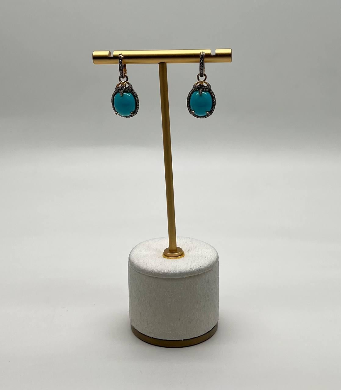 A striking pair of earrings, each featuring a vibrant turquoise stone, encased in a delicate halo of small, sparkling diamonds. The stones are suspended from a sleek, gold hoop, adding a touch of elegance and sophistication.
14K Yellow Gold
Natural