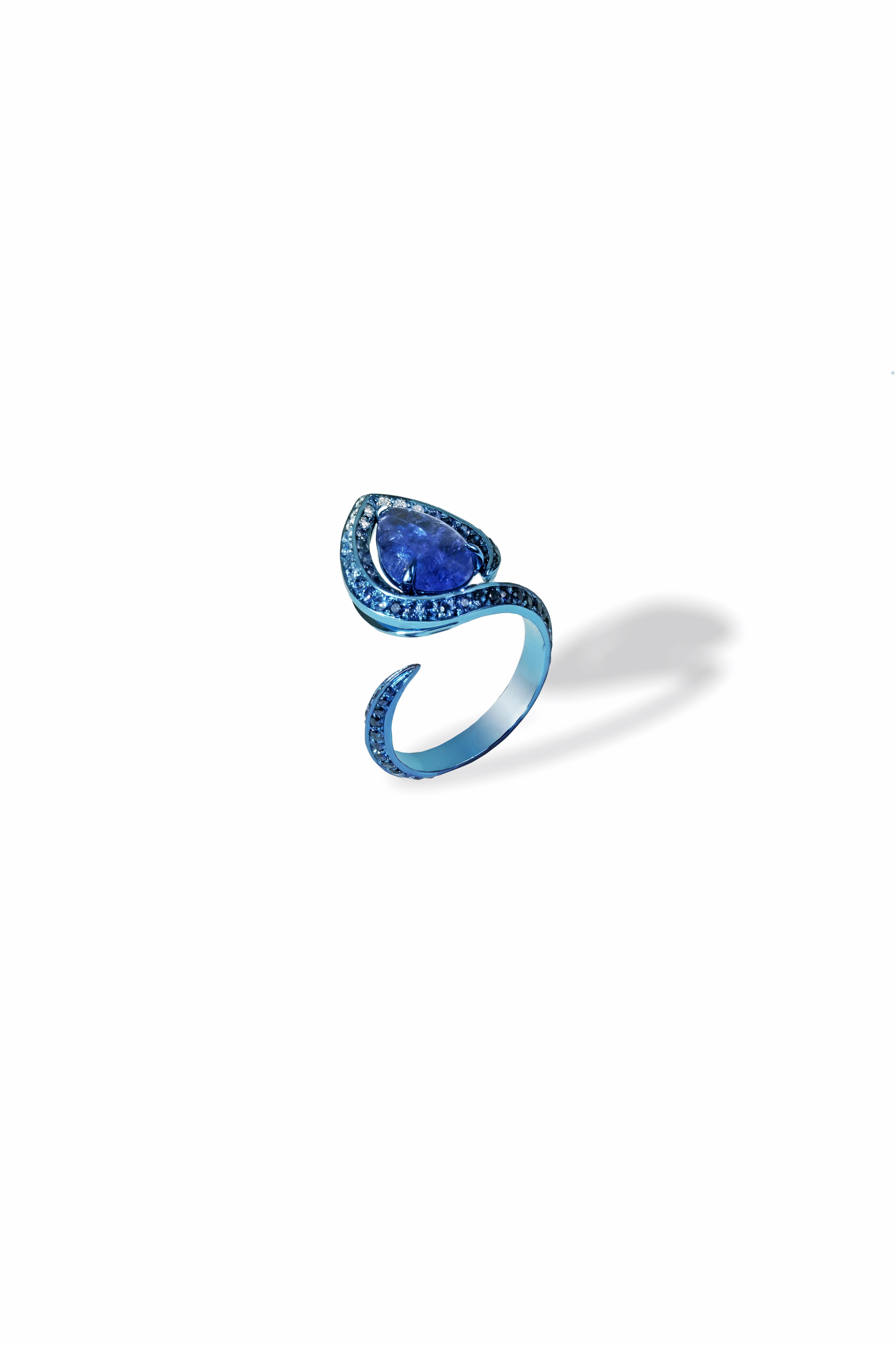 Handgefertigter Ring aus blauem Titan mit 119 Steinen in der Hand: Tansanit-Cabochon 2,25 ct,
Saphire 1,87 kt. und weiße Diamanten 0,12 kt. Die filigranen Arbeiten aus Titan werden von hochqualifizierten Handwerkern in Italien von Hand