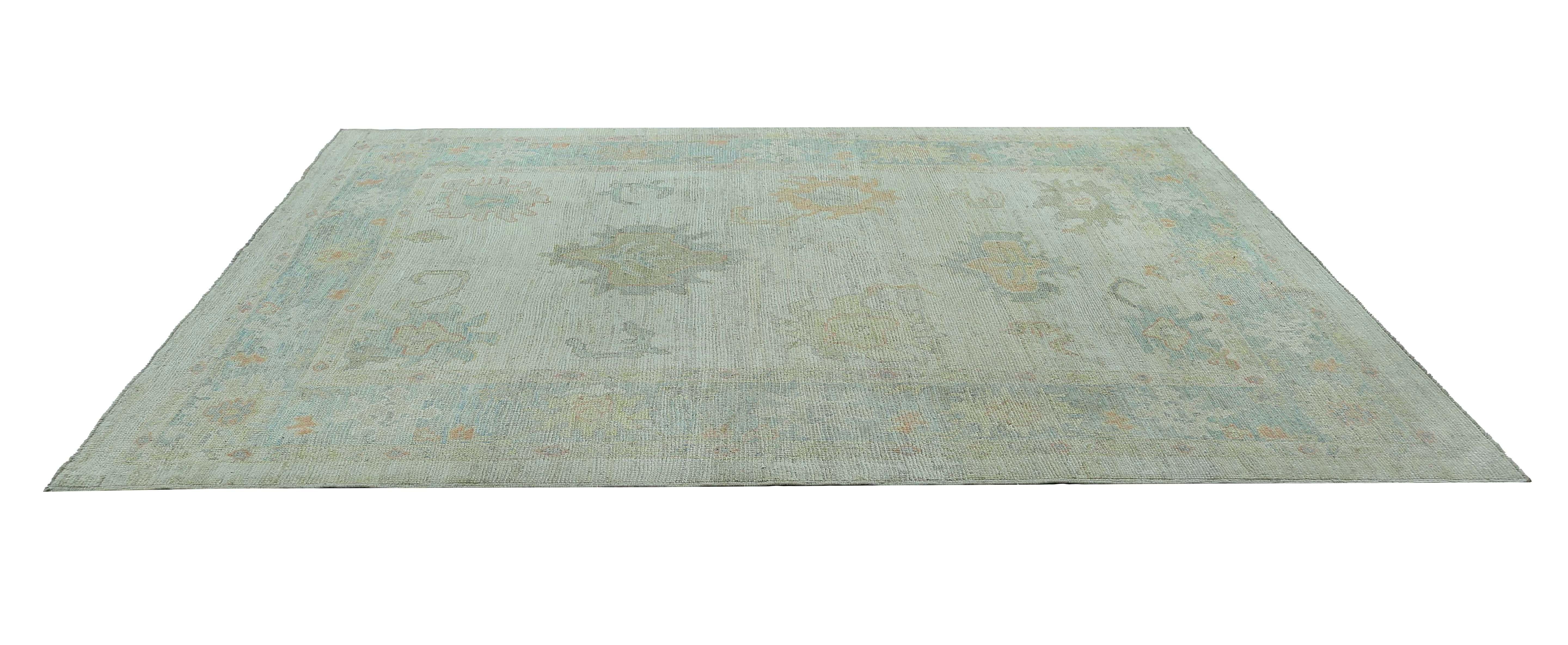 Elevate your home decor with our exquisite 6'8'' x 9'7'' Oushak rug, featuring a stunning array of blue tones that create a mesmerizing effect. This rug is handwoven from premium quality wool, providing a soft and comfortable underfoot experience