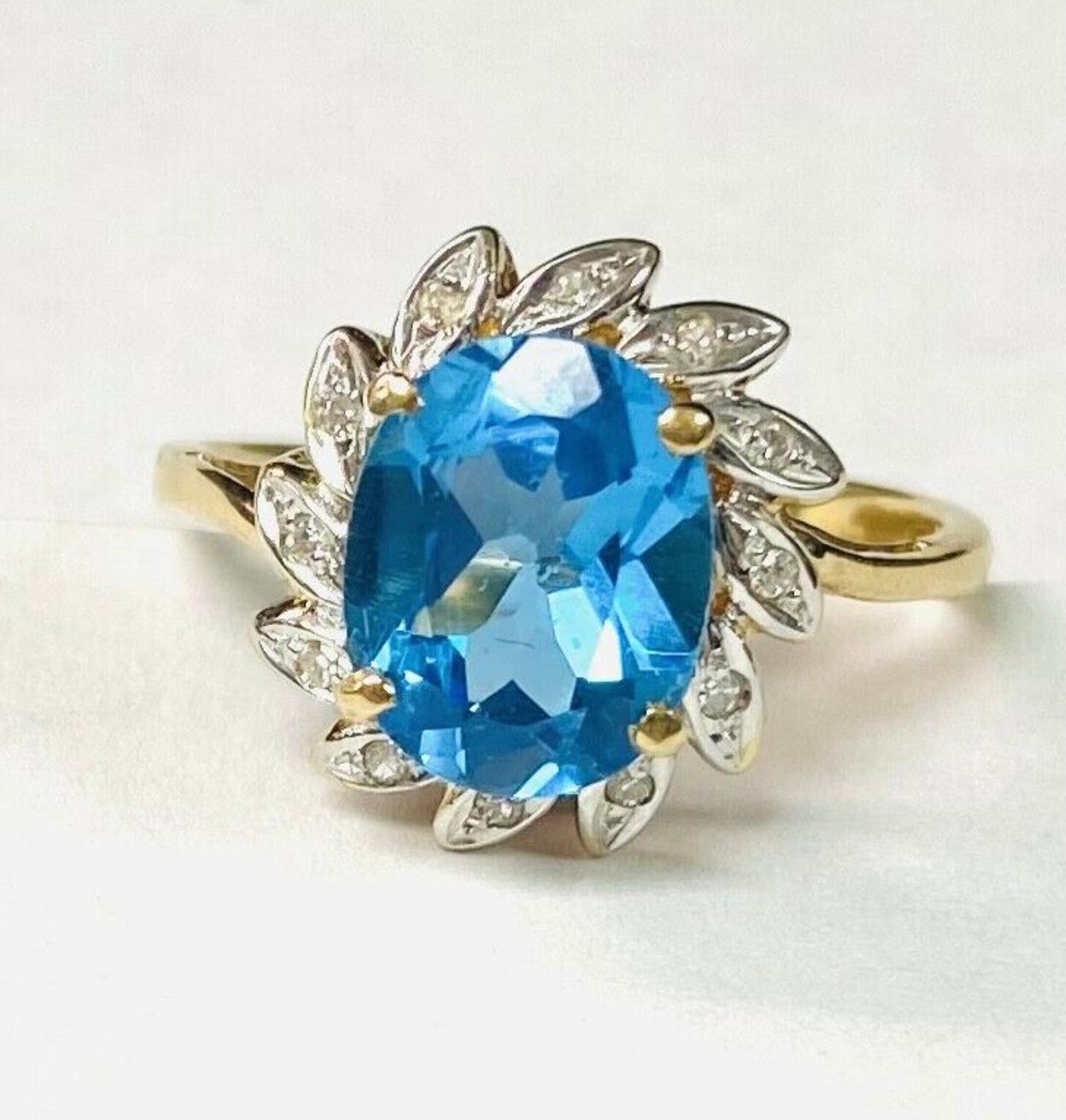 14k yellow gold blue topaz and diamond ring. The dimensions of the oval aquamarine are approximately 11.5 mm x 7.5mm. Approximately 3 carats. Marked 14k. Approximate size 7.5.