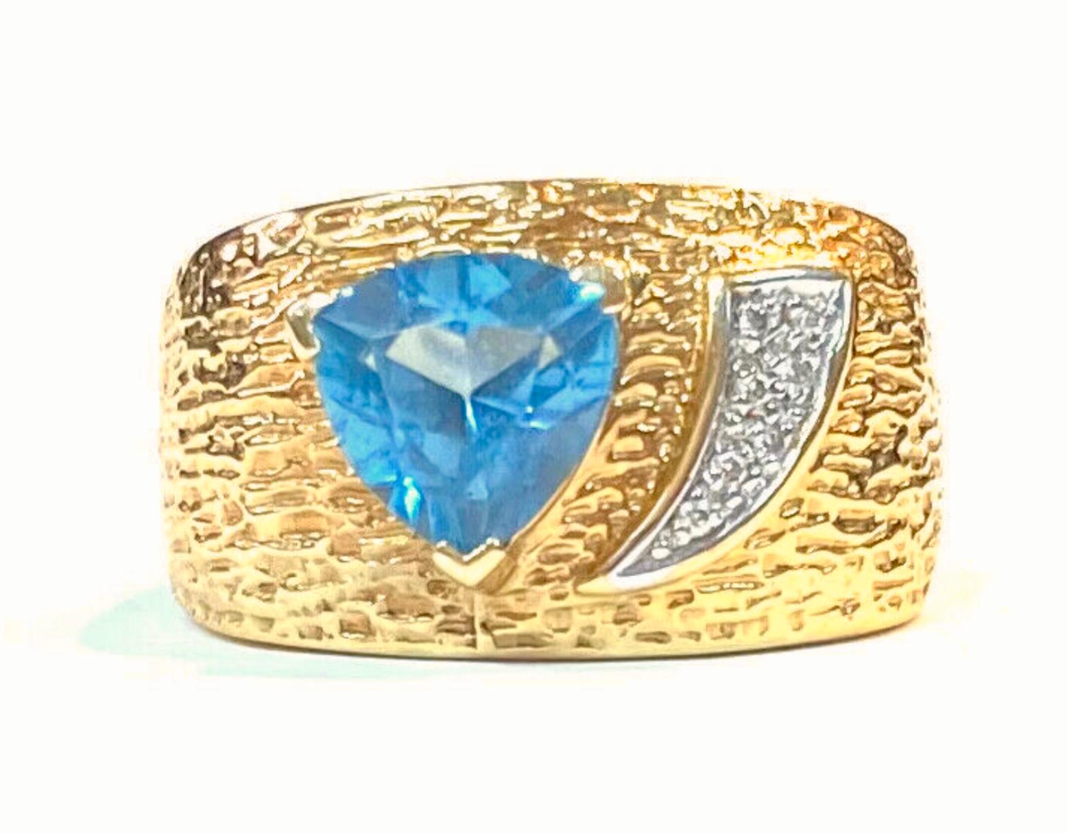 14k yellow gold wide band blue topaz and diamond ring, 11.55 Grams TW. The dimensions of the Trillion Blue Topaz are approximately 7 mm x 7 mm. Approximately 1.5 carat. Marked 14k. Approximate size 7.