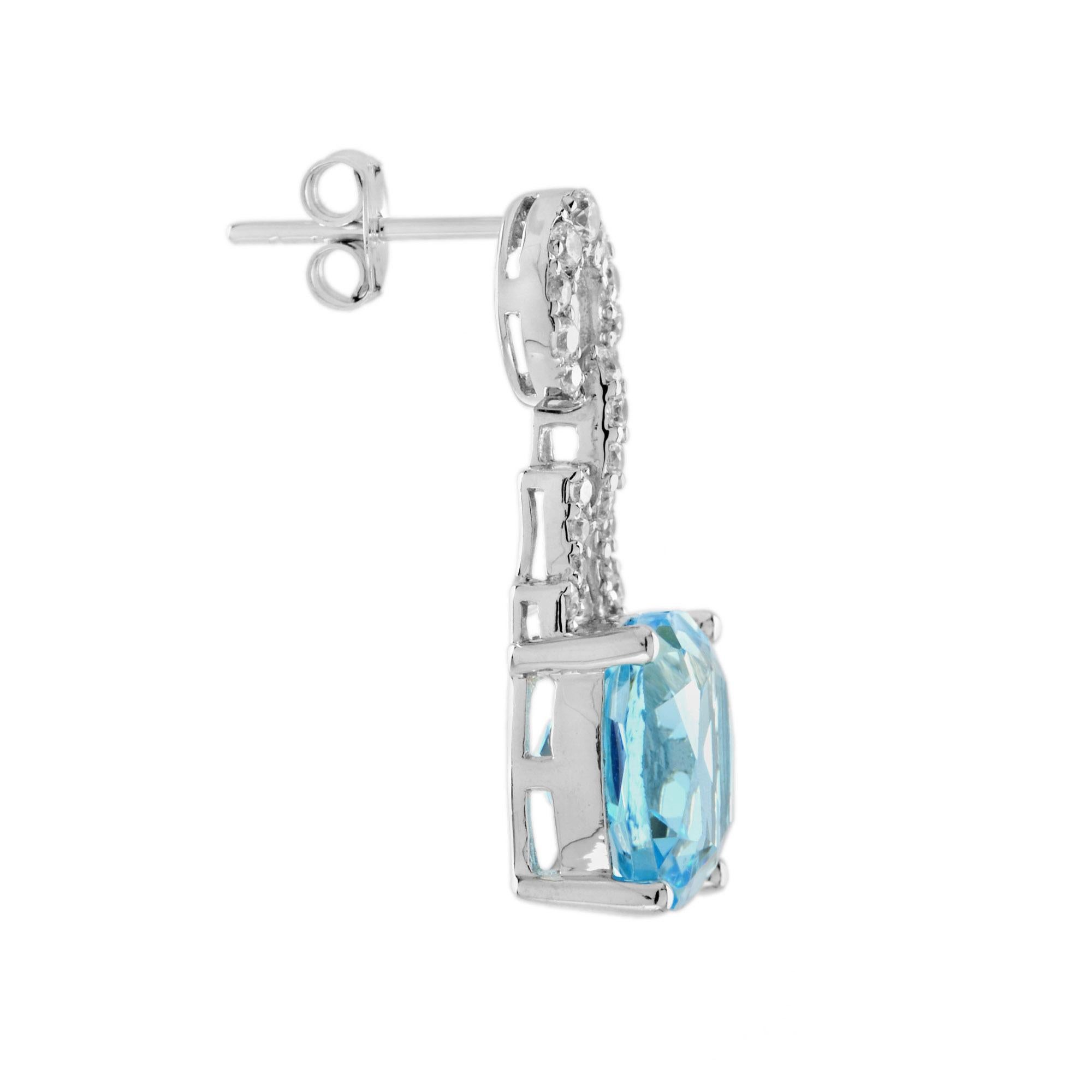 These graceful drop earrings are mounted in white gold. Each of these outstanding drop earrings feature a cushion cut sky blue topaz gemstone and diamonds. Pair them with your favorite casual, professional or dressy outfit and look