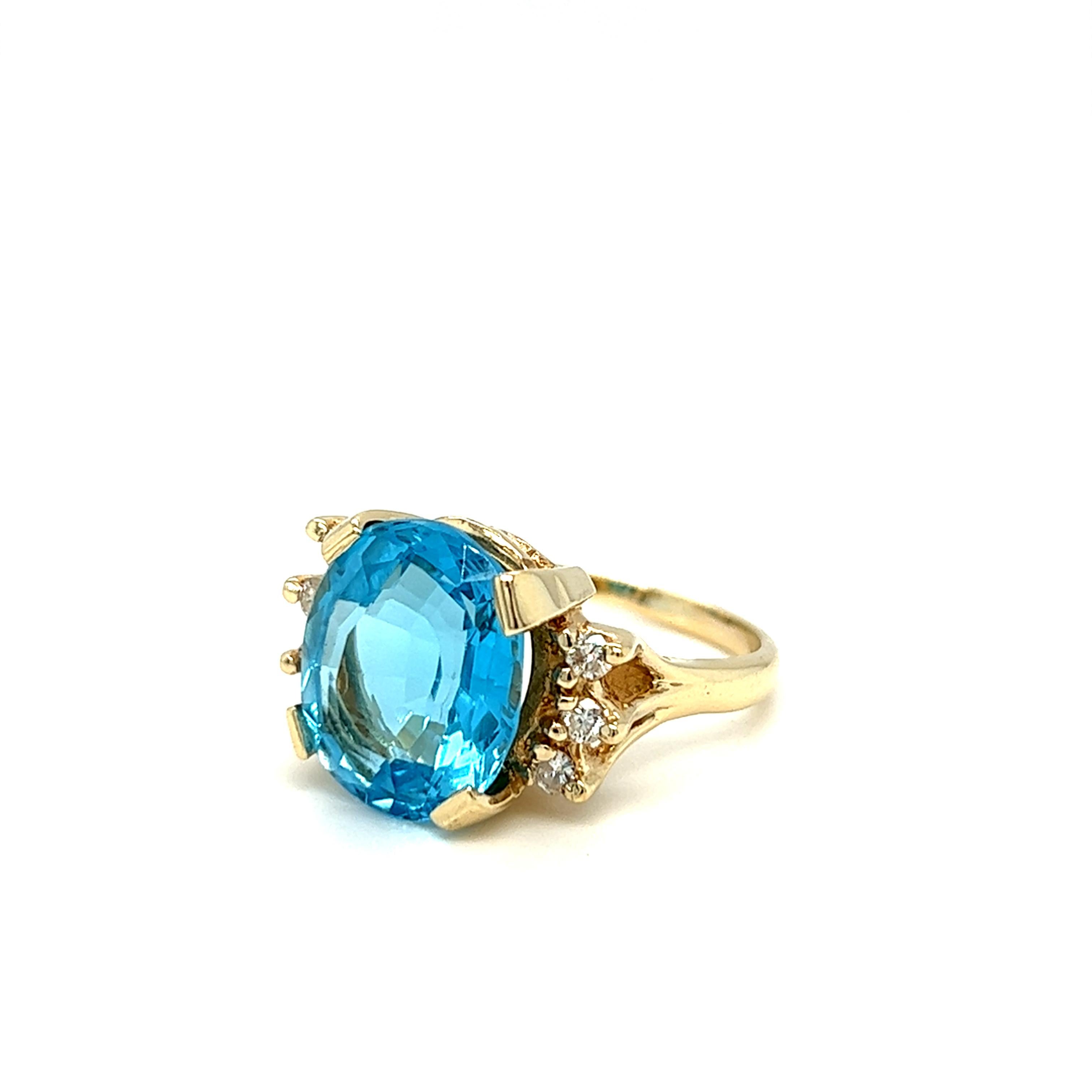 Vintage cocktail ring features a gorgeous oval shaped blue topaz at center, weighing approximately 11 carats. The center stone is held by four wide flat prongs and set in 14k yellow gold handmade setting split shoulders with branch like motif