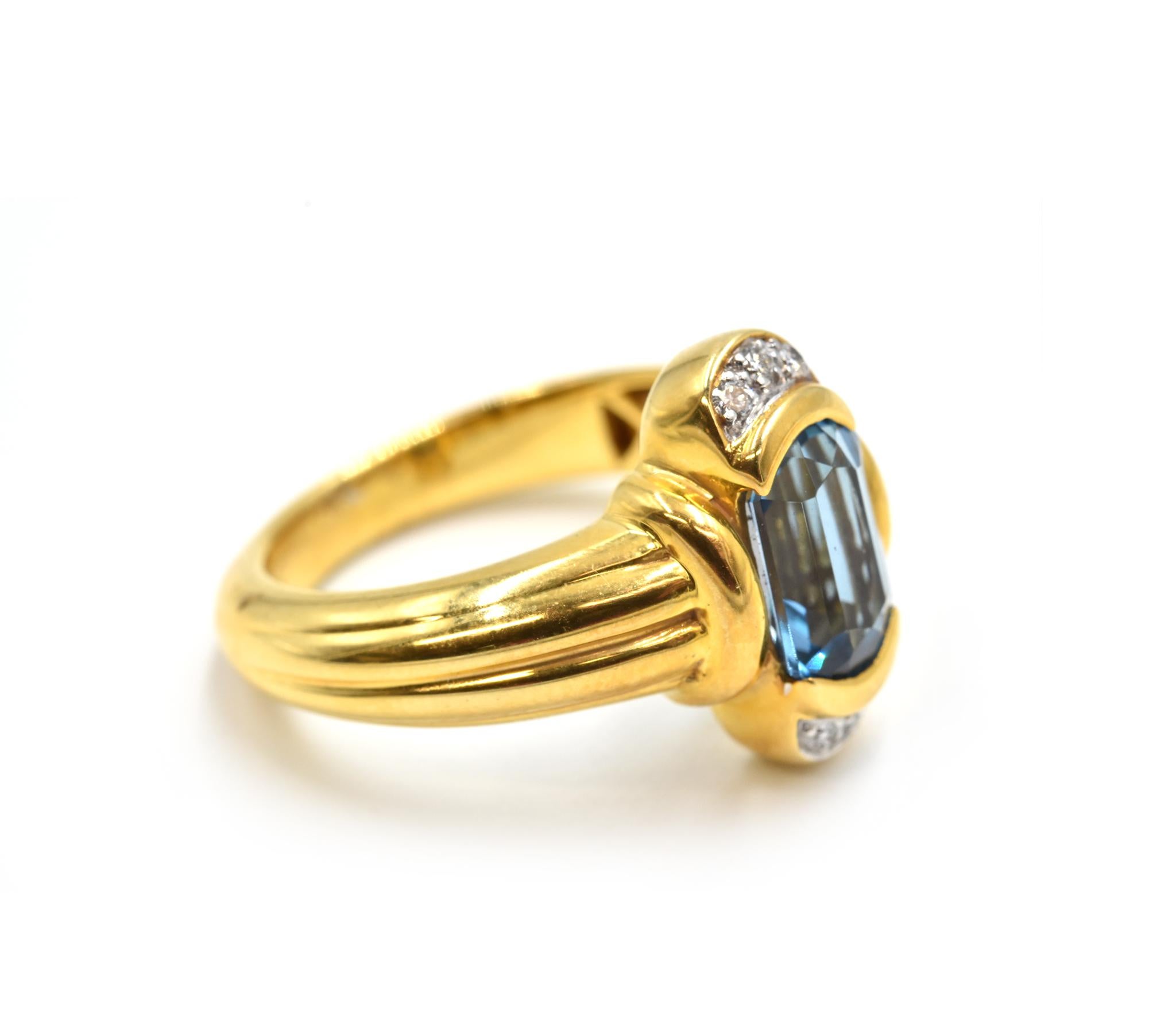Designer: custom design
Material: 18k yellow gold
Blue Topaz: one 1.60 carat blue topaz gemstone
Diamonds: six round brilliant cut diamonds = 0.10 carat weight
Dimensions: ring top measures 1/4-inch long
Ring Size: 6 1/4 (please allow two additional