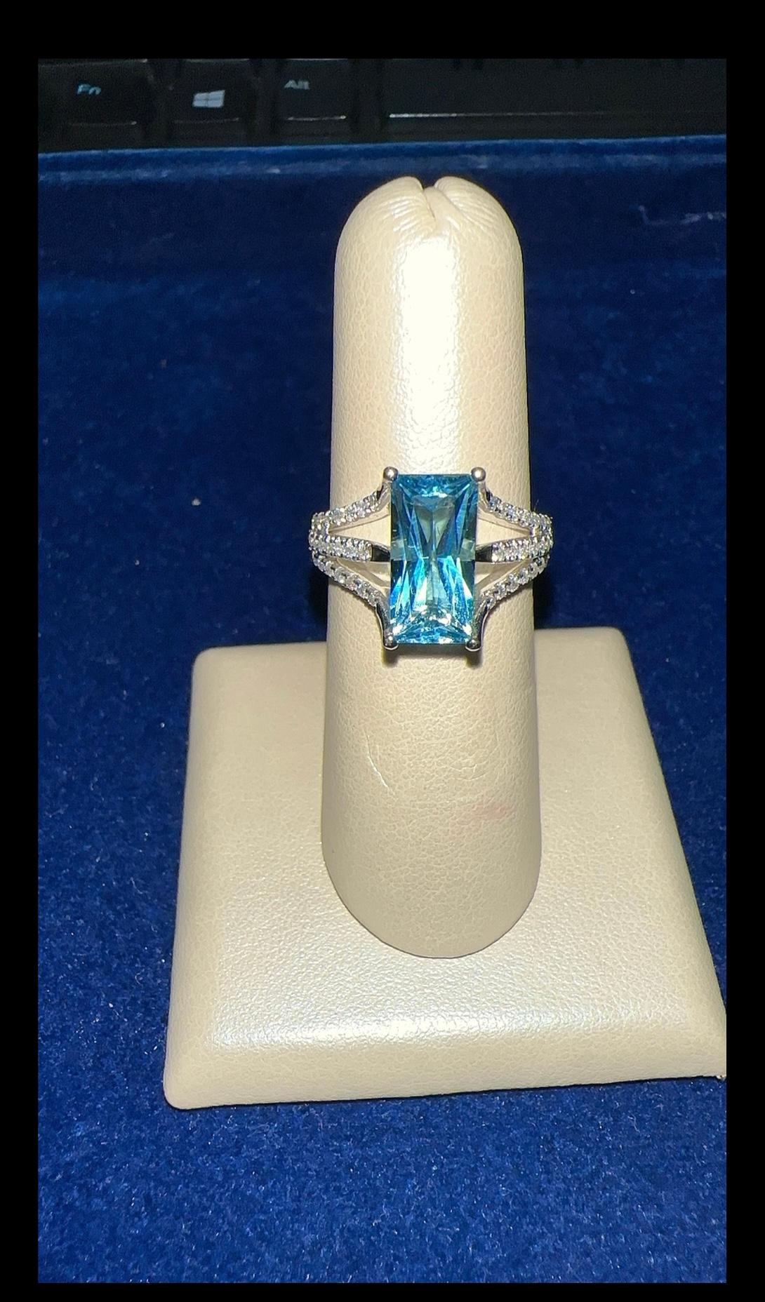 Un unico e splendido anello con topazio blu e diamanti in oro bianco 14 carati. Un pezzo lussuoso che mette in risalto l'eleganza con le nostre gemme naturali, fatto apposta per indossare la perfezione ogni giorno.