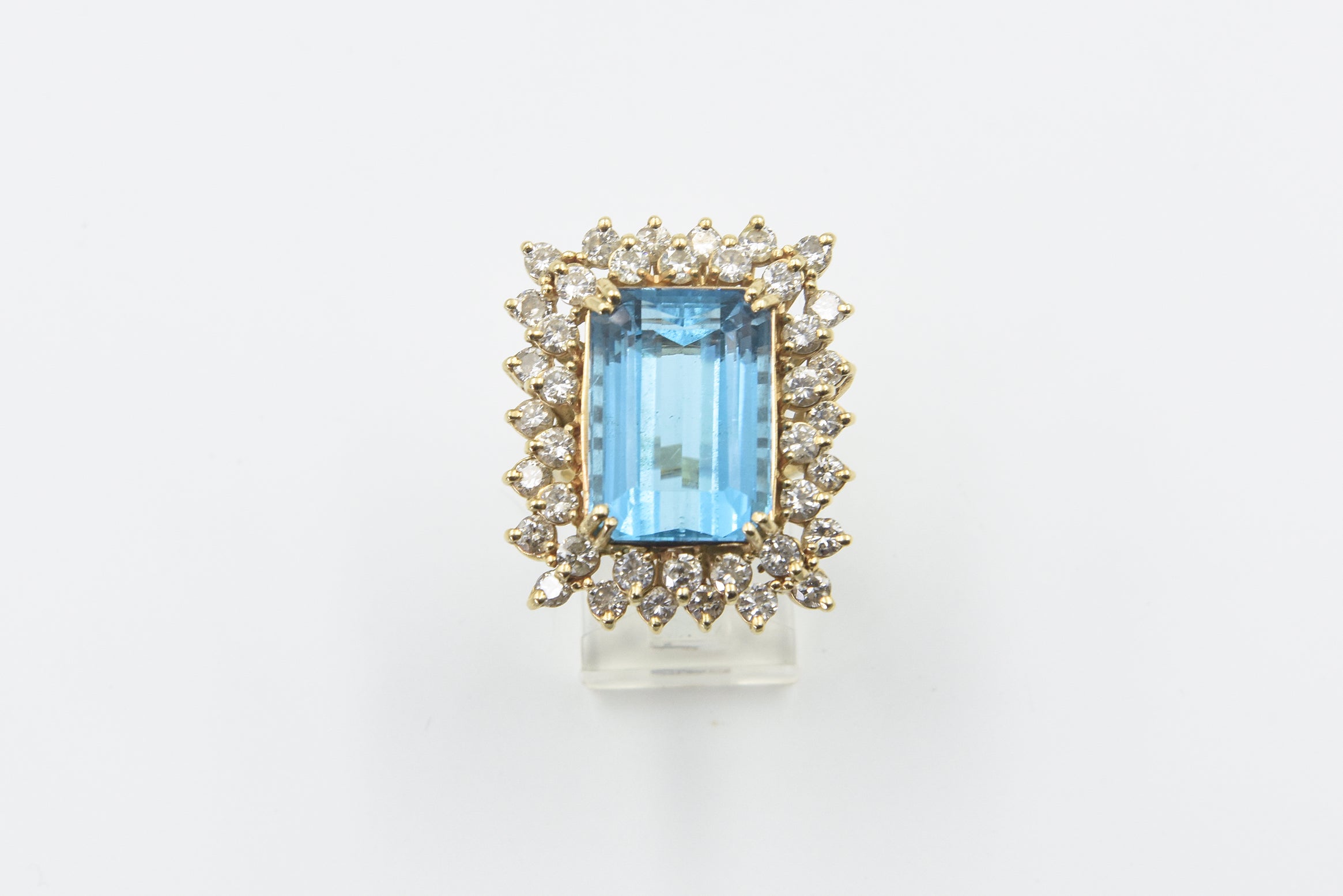 Gorgeous emerald cut blue topaz mounted in two tier diamond frame.  The blue topaz weights approximately 18 carats.  The mounting has approximately 3.36 carats in diamonds set in a 14k yellow gold mounting.  The ring size is 7.25 US.  