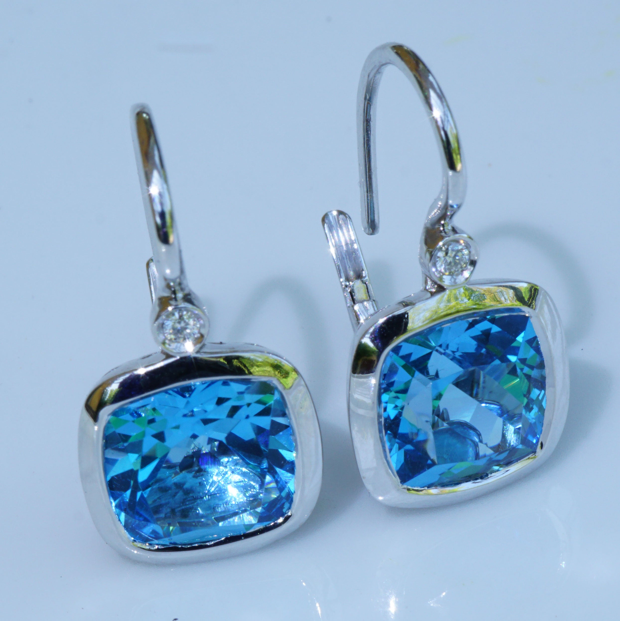  Earrings of high quality made in a traditional Italian goldsmith in Valenza, each a square cushion-shaped cut blue topaz total approx. 7.29 ct, translucent underlined in the noble diamond-shaped openwork pattern, two full-cut brilliant-cut diamonds