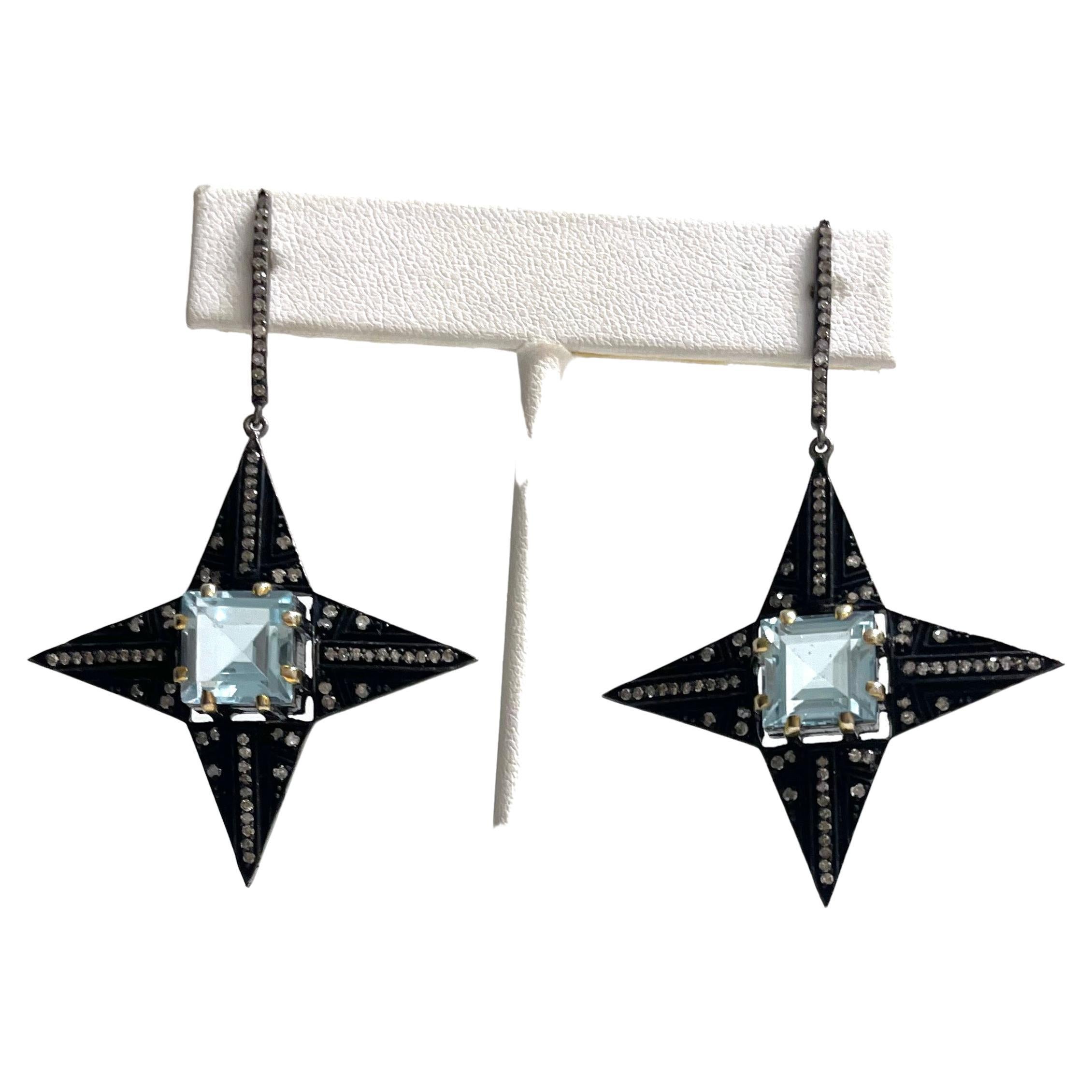 Description
These unique and stylish earrings feature a striking Blue Topaz surrounded by pave diamonds set in a bold black four-pointed star creating a dramatic, galaxy starry night eye catching effect.
Item # E3308

Materials and Weight
Blue