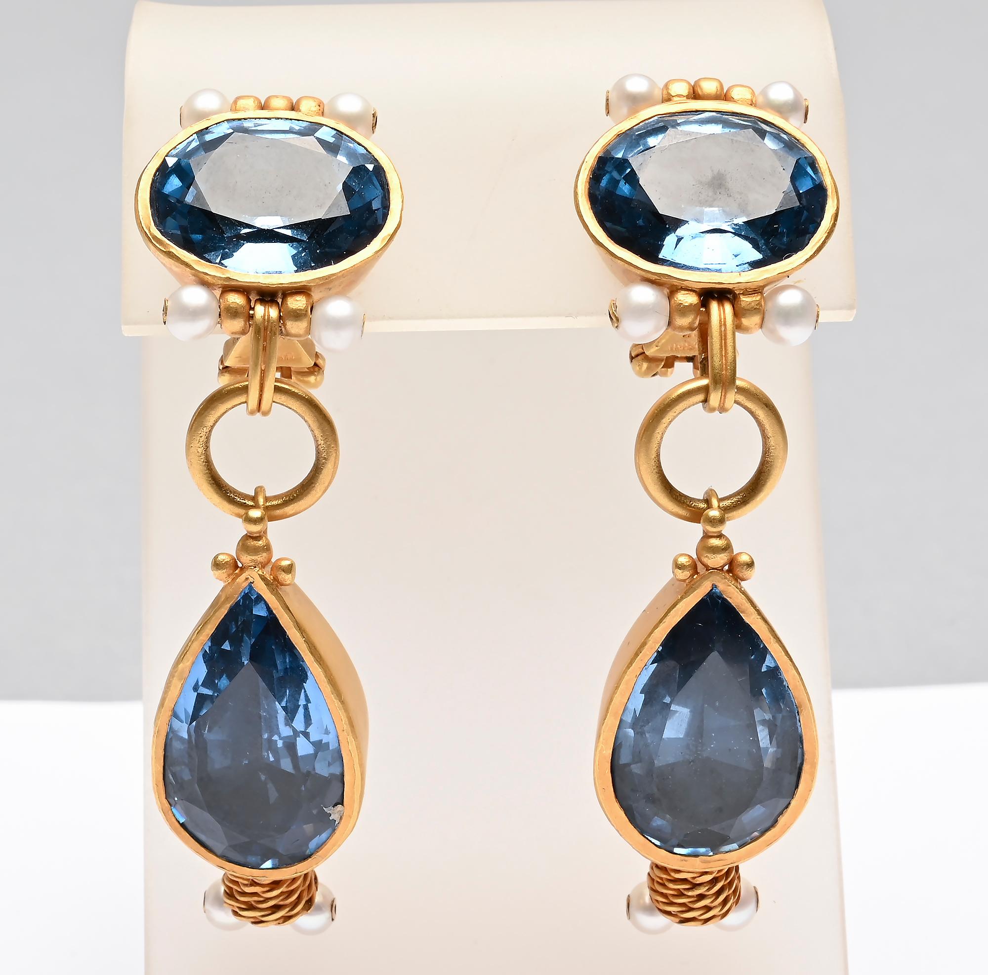 Most unusual and elegant 18 karat gold earrings with two large blue topaz stones. The top is oval, measuring 5/8