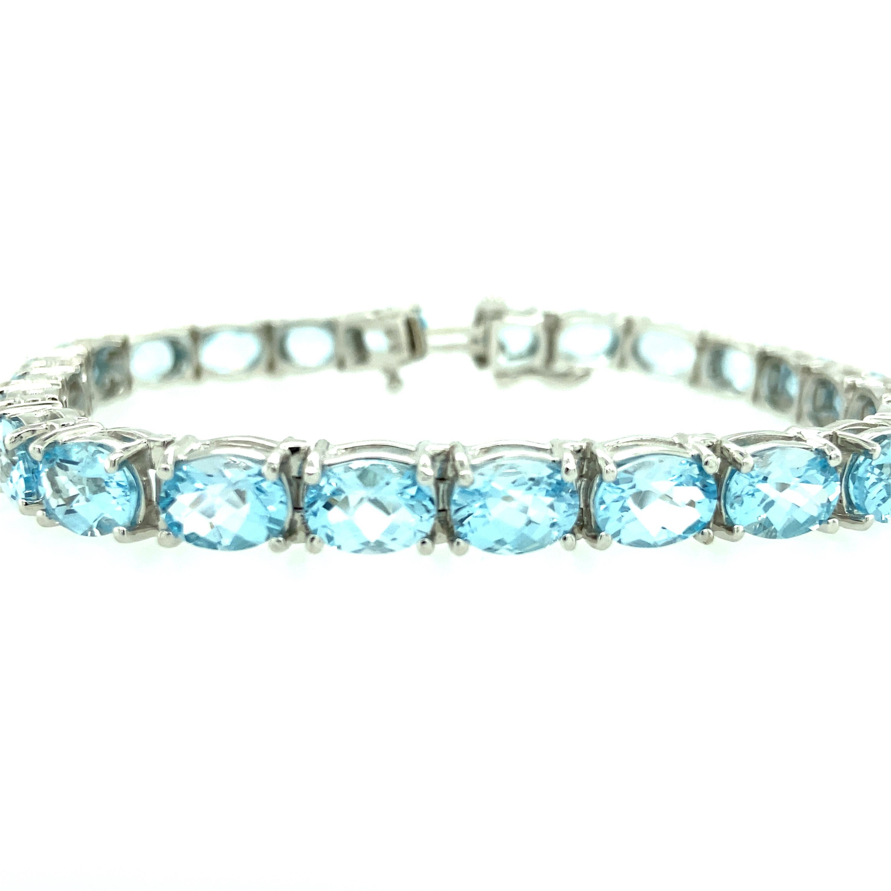 One 14 karat white gold estate line bracelet set with twenty-four oval blue topaz.  The bracelet measures 8 inches long and is secure with a box clasp and safety closure.
