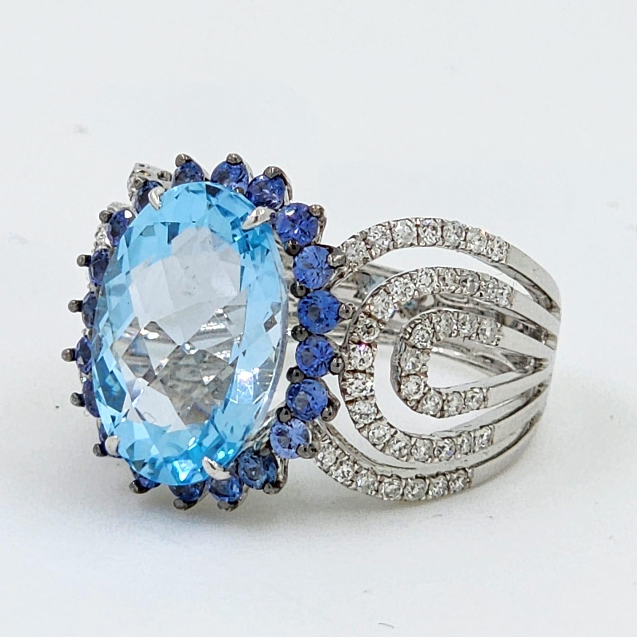 This cocktail ring features a faceted oval cut blue topaz weight 6.96 carats in the center, the center blue topaz is surrounded by 0.71 carats of blue sapphire. The shoulder of the ring is set with 0.55 carats of white round
