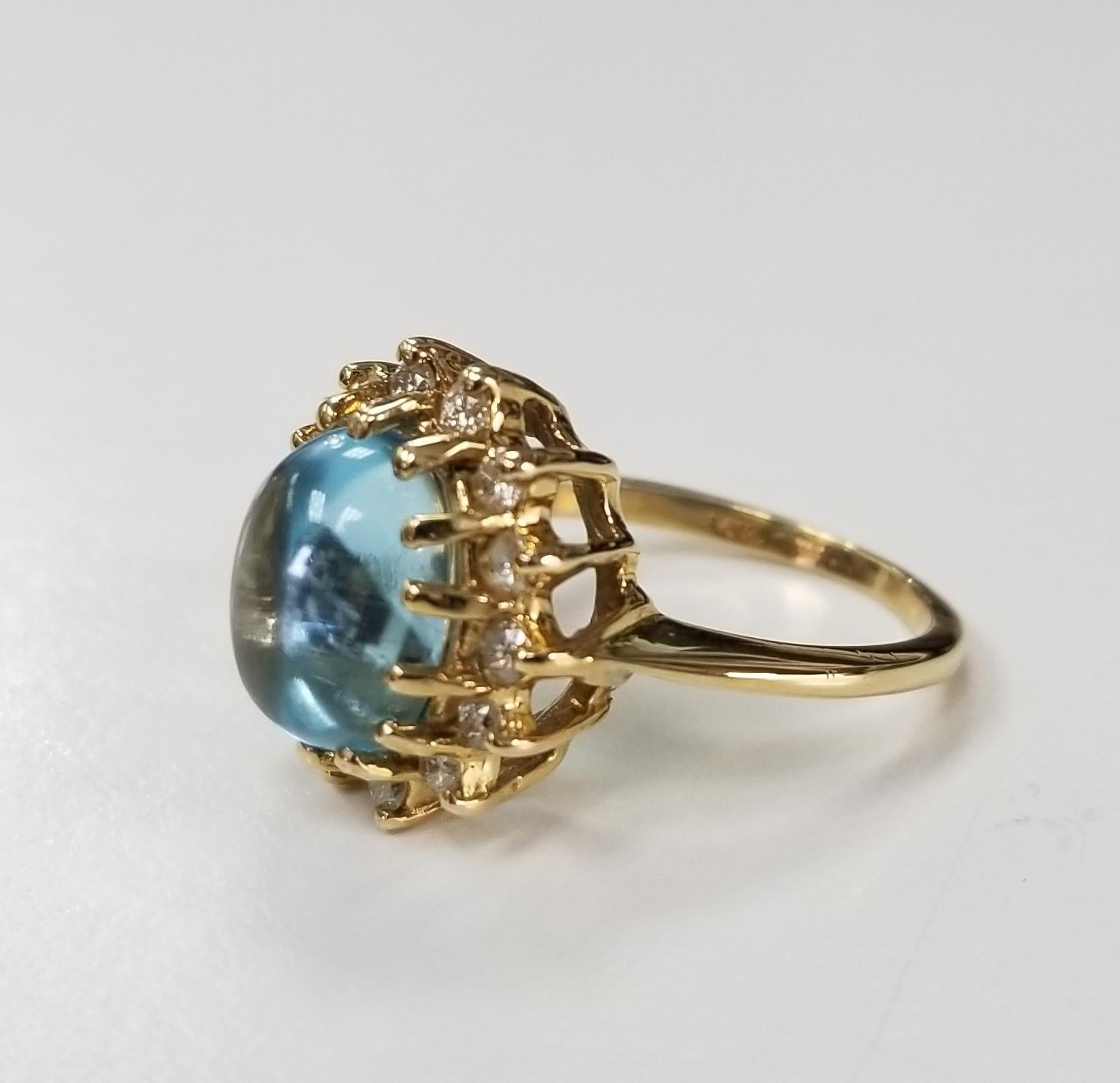 14k yellow gold Blue Topaz Cabochon and Diamond ring, containing 1 oval cabochon cut blue topaz weighing 3.75cts. and 14 round full cut diamonds weighing .40pts.  This ring is a size 5 but we will size to fit for free.