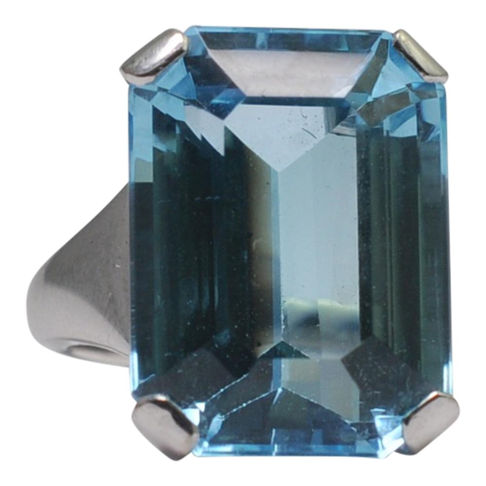 Spectacular and dramatic blue topaz cocktail ring; the topaz is a deep swimming pool blue and weighs 26.8ct.  It is mounted is a solid white 18ct gold 4 claw setting with wide shoulders.  This ring really makes a statement and is fully English 18ct