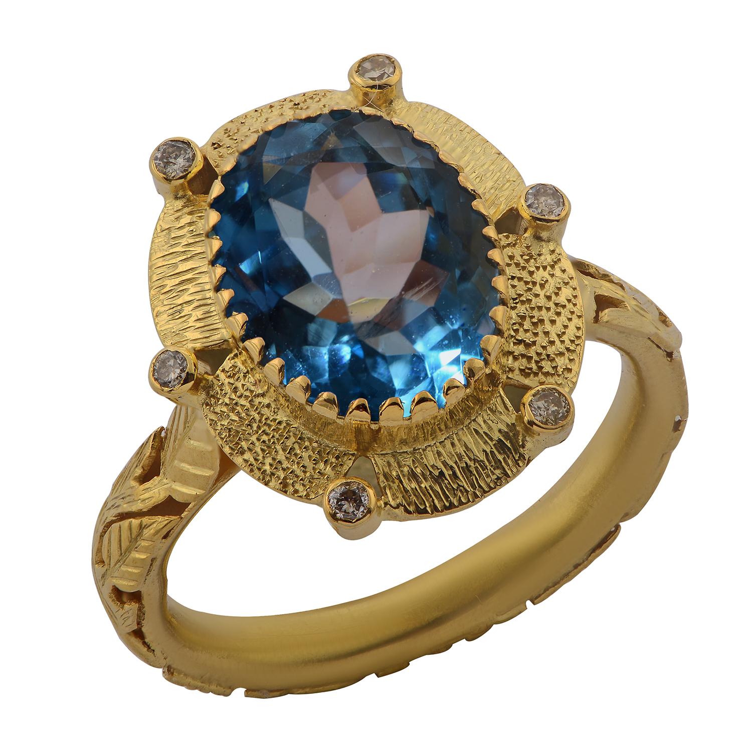A striking one-of-a-kind blue topaz and diamond 18k gold cocktail ring. Handmade in our workshops, this ring features a 4.45 flawless blue topaz, which is flanked by six full cut diamonds set in exquisite hand-engraved 18k gold floral motifs.
The