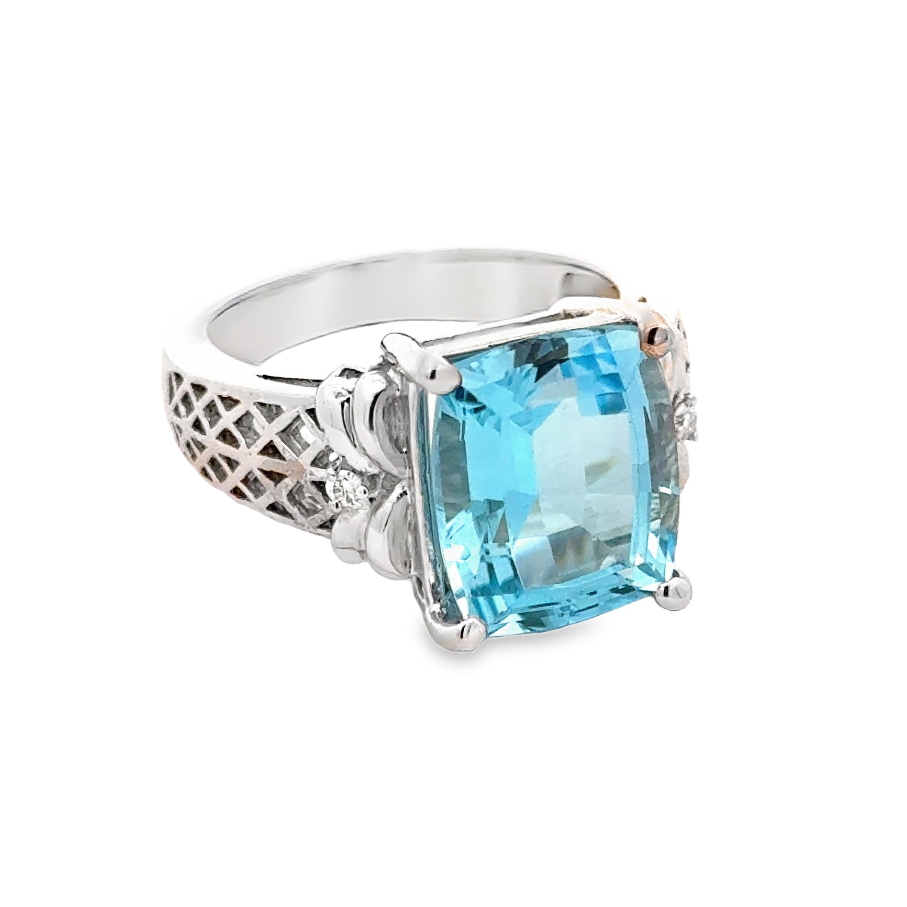 Questo squisito anello da cocktail vanta un topazio blu da 6,98 carati con taglio a cuscino su una fascia in oro bianco 14 carati, ornata da diamanti scintillanti. La vibrante gemma blu e i diamanti scintillanti rendono questo anello un pezzo forte