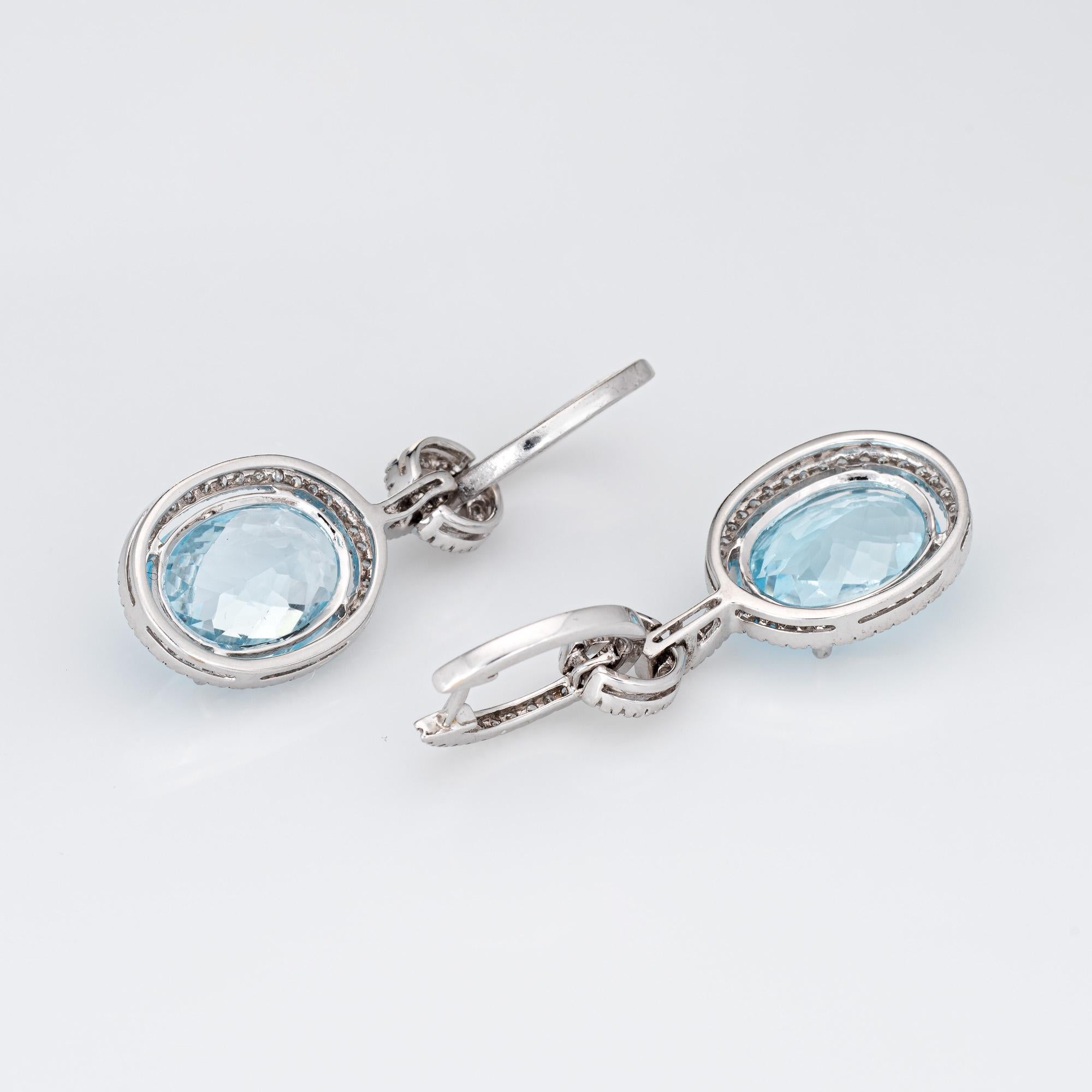 Elegant pair of blue topaz & diamond drop earrings crafted in 14k white gold. 

Faceted oval cut blue topaz measures 14mm x 10mm (estimated at 5.50 carats each - 11 carats total estimated weight). Single cut diamonds total an estimated 0.68 carats