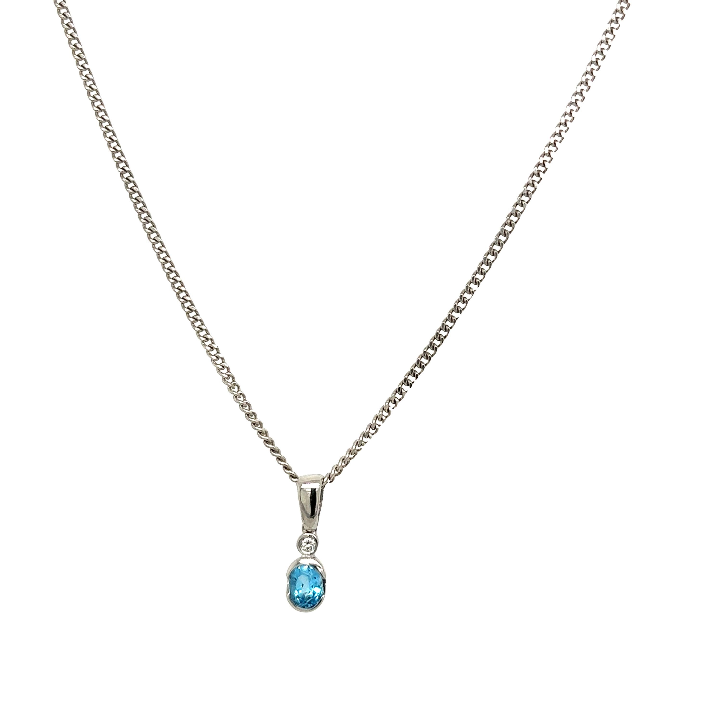 This gorgeous diamond and blue topaz pendant is set with a round brilliant cut diamond and an oval shape blue topaz in 18ct white gold. The pendant is suspended from an 18-white gold chain that measures 16 inches.

Item Length: 16