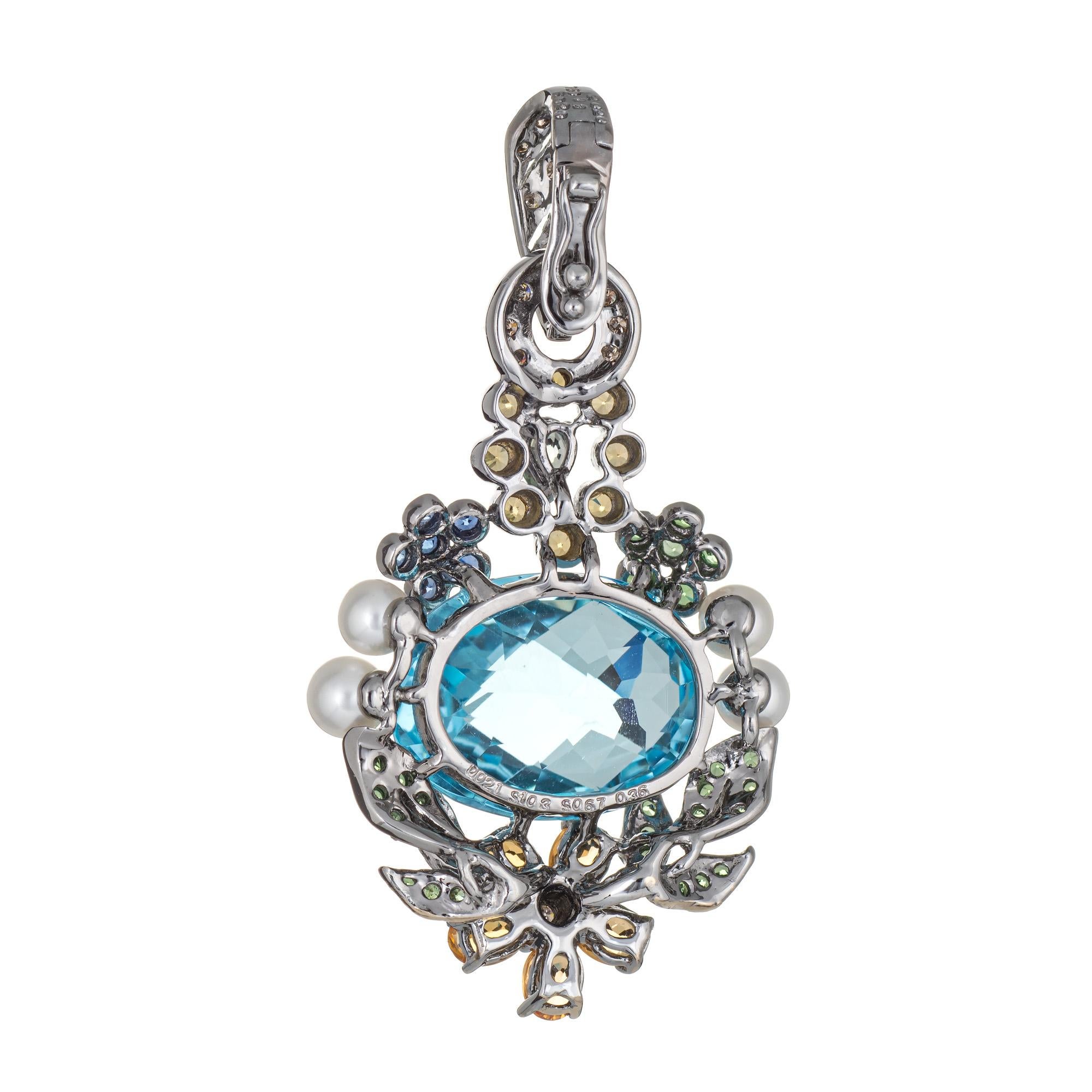 Finely detailed estate pendant set with blue topaz, diamonds & multi gemstones crafted in 18k oxidized white gold.  

Centrally mounted checkerboard faceted blue topaz measures 17mm x 13mm (estimated at 17 carats). The diamonds total an estimated