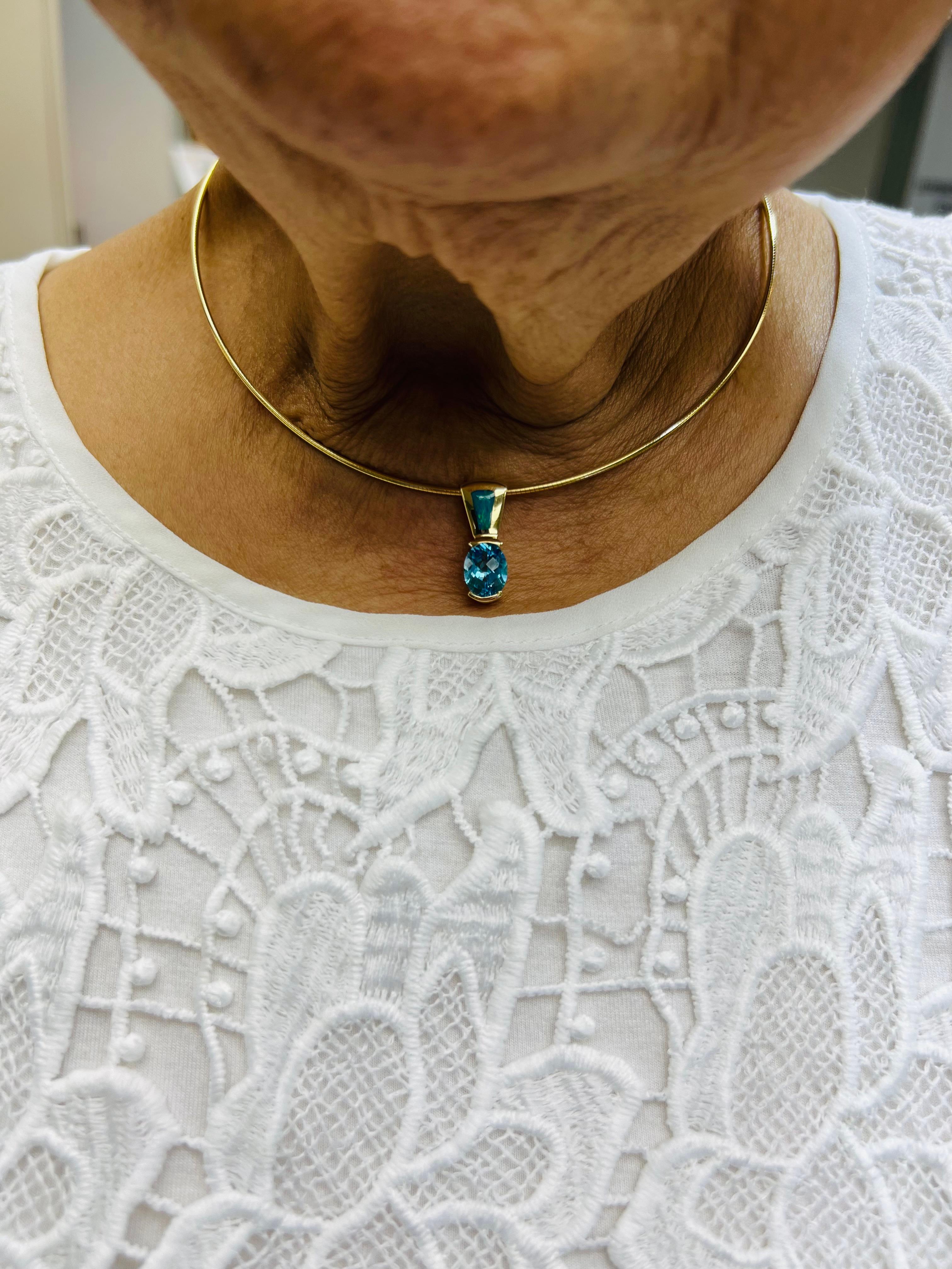Blue Topaz Opal yellow gold slide pendant necklace.

The Blue Topaz Opal Yellow Gold Slide Pendant Necklace is a captivating piece of jewelry that exemplifies the intersection of natural beauty and artisanal craftsmanship. This necklace features a