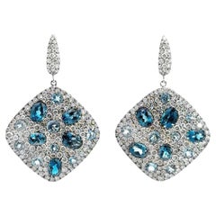 Boucles d'oreilles pendantes en or blanc 18k avec topaze bleue et diamant serti clos