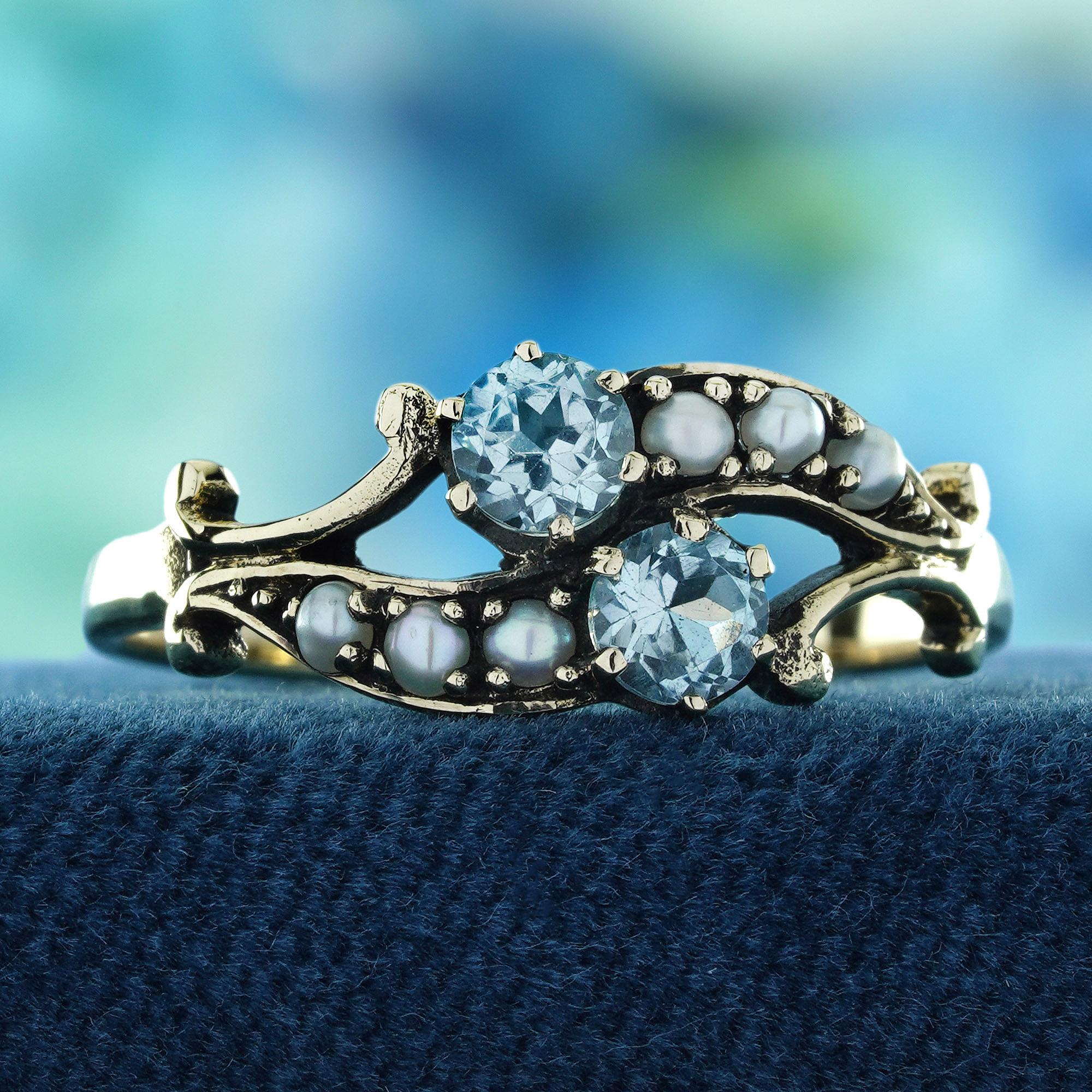 Lasciati incantare dall'eleganza della natura con questo anello a due pietre in stile vintage con perla e topazio blu naturale. Il sereno topazio blu, che ricorda i cieli limpidi e le acque tranquille, si abbina magnificamente al bagliore senza