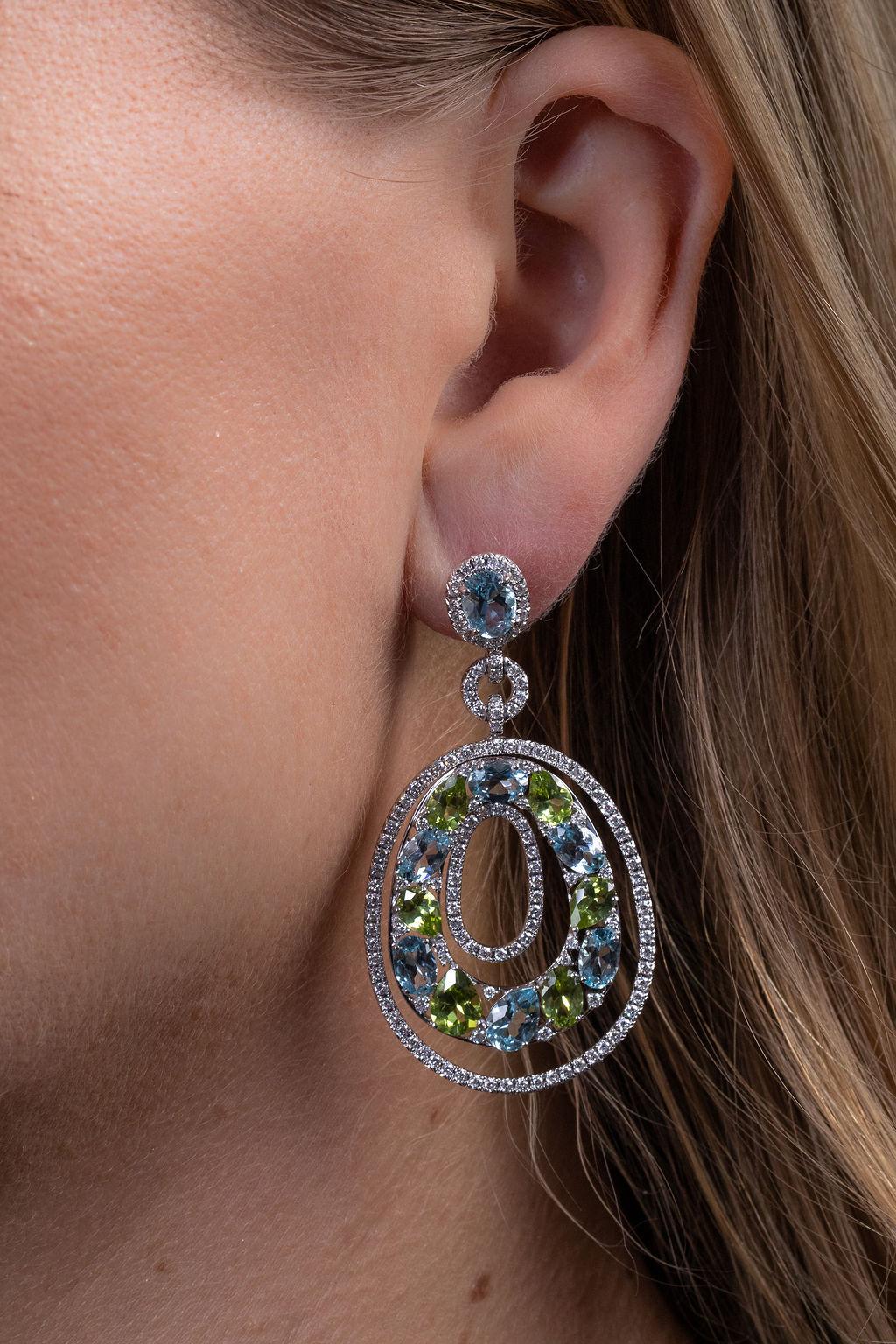 Blue topaz and peridot complemented by white diamonds create a beautiful, fresh look reminiscent of the natural beauty of the ocean and forest.  Just over two inches in length.  Created in 18k white gold.