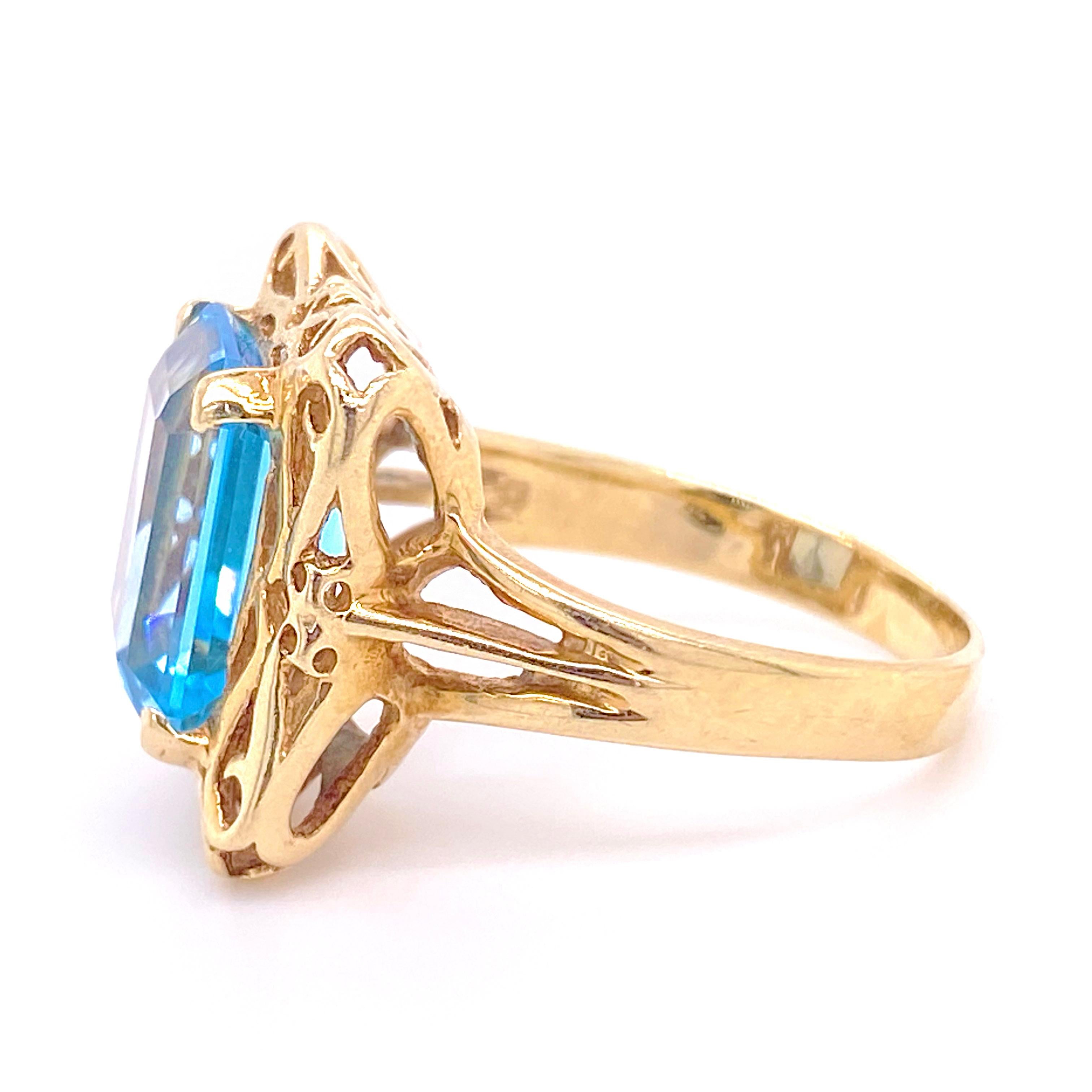 The emerald cut blue topaz ring has 3.62 carats! This ring has lots of luscious 14 karat gold on it and is a filigree design. The ring is hardy and sturdy with lots of gold to protect the gemstone. The Swiss blue color of the stone makes it a very