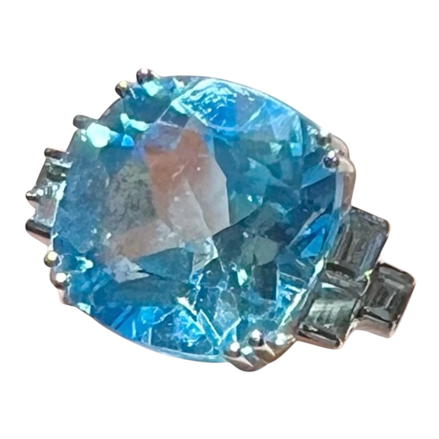 importante bague en or blanc 18 carats, sertie en son centre d'une très belle topaze bleue de 9,08 carats joliment facettée rendant les lumières du mouvement de l'eau claire,
entouré de 6 diamants calibrés pour 0,20 carat au total. 
poids total :