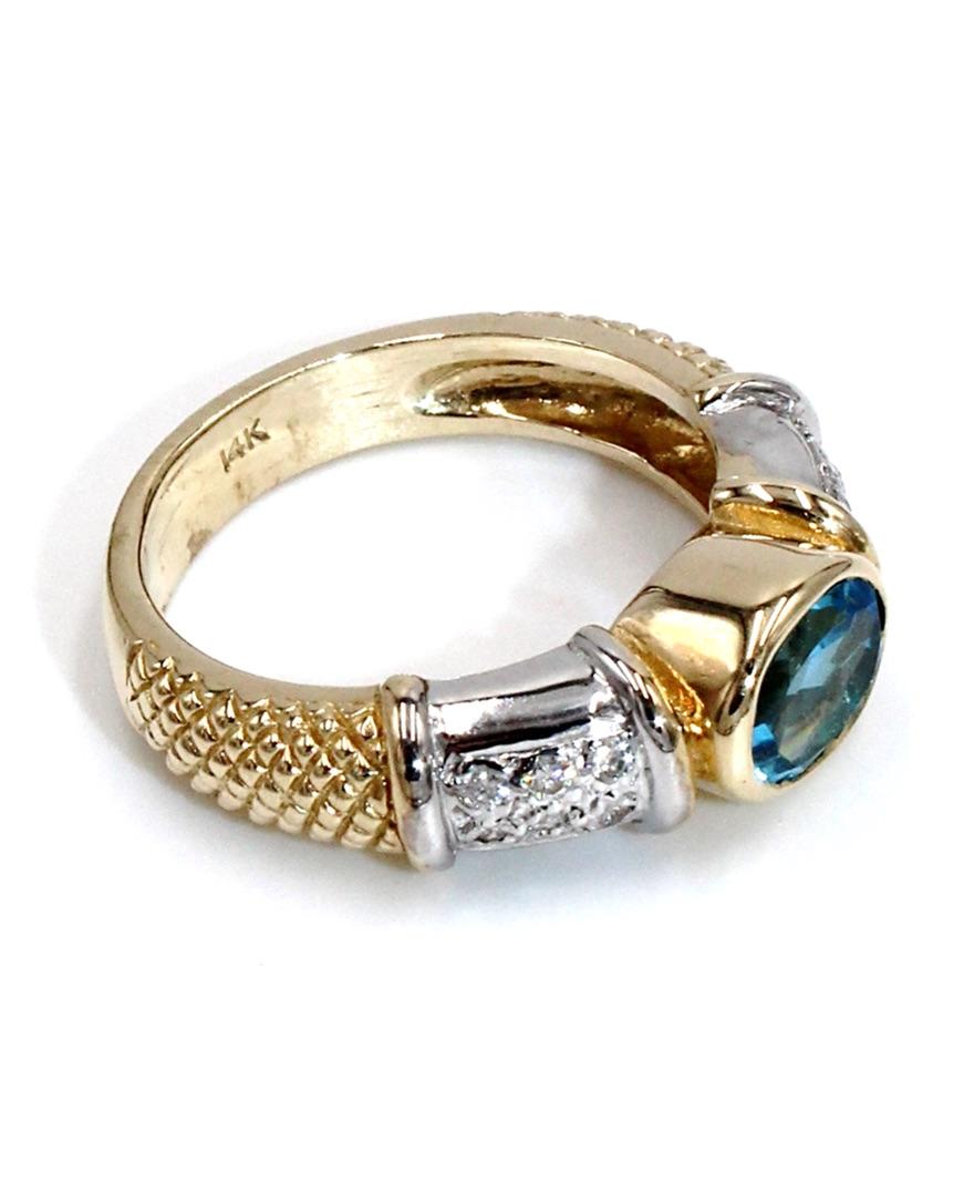 14k white and yellow gold right hand ring with one oval shape blue topaz measuring approximately 8.0x6.0mm and 0.12 carat round brilliant-cut diamonds.

* Finger size:  9.25