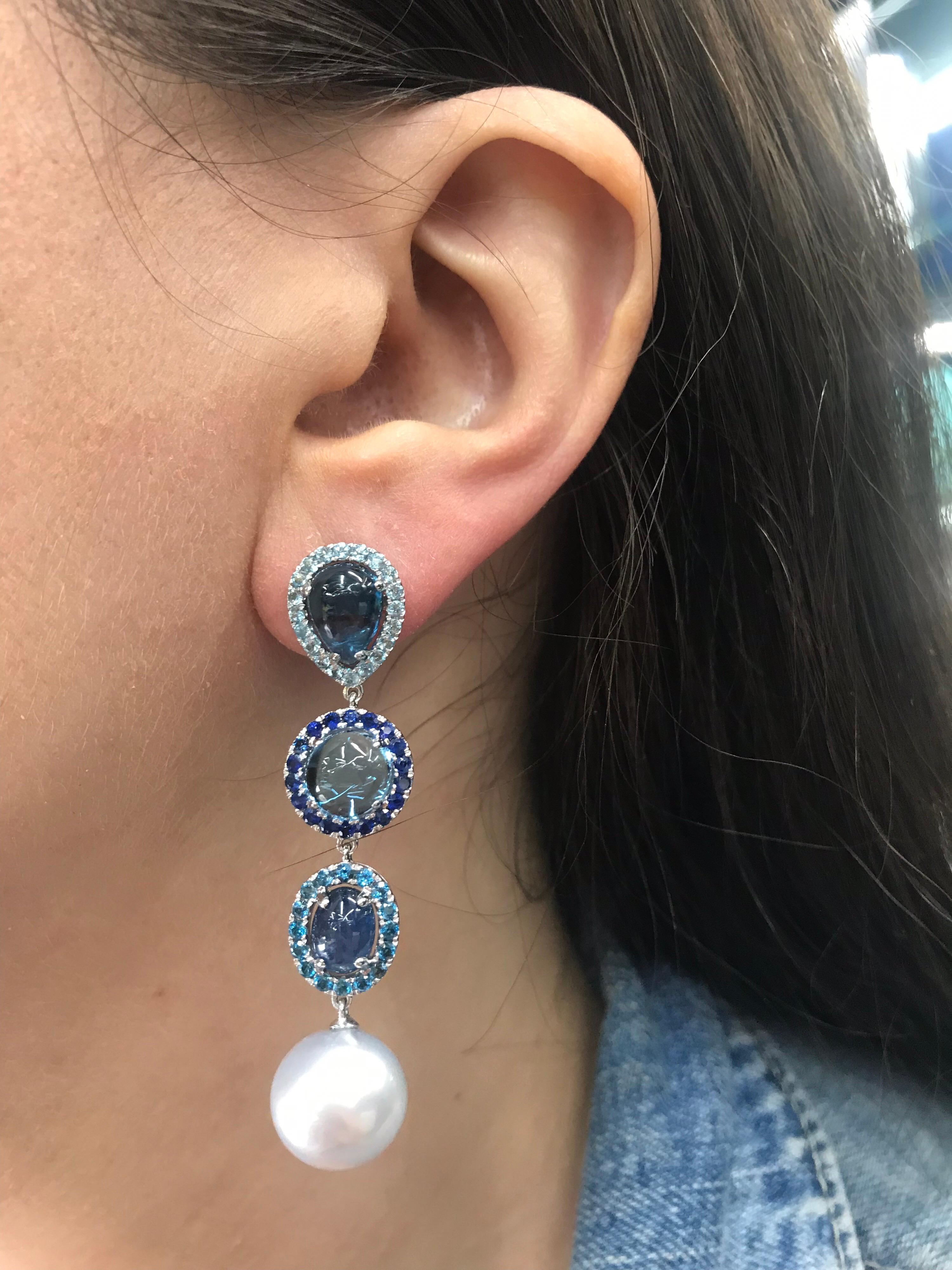 18K White gold drop earrings featuring alternating blue topaz, 12.50 carats, and sapphires 4.50 carats with two white South Sea Pearls measuring 12-13 mm. 