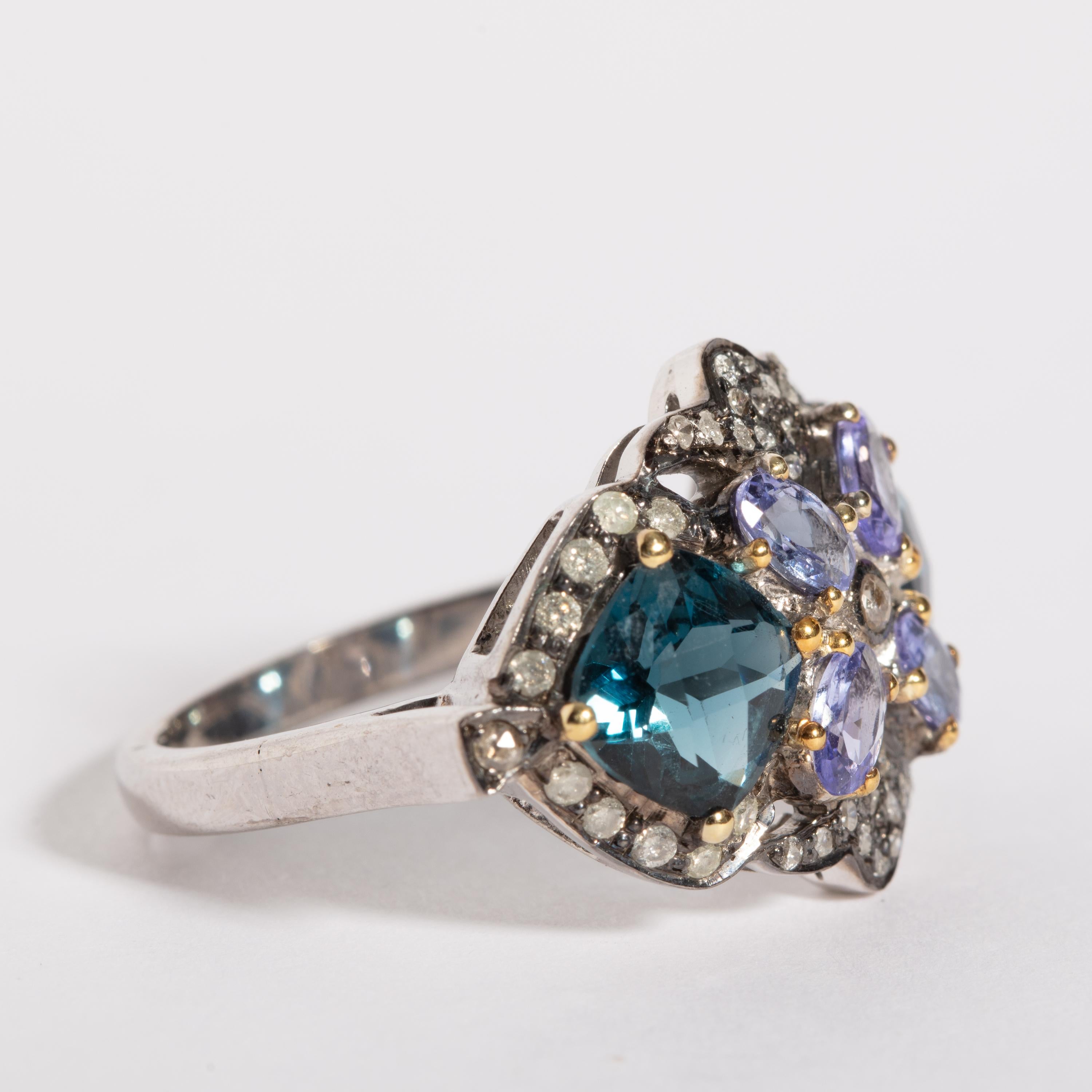 A cluster of faceted round blue topaz with faceted oval tanzanite stones, all bordered with brilliant-cut diamonds. Set in sterling silver. Weight of diamonds is .70 carats, tanzanite is .7 carats and blue topaz total 3 carats. Ring size is 7.75.