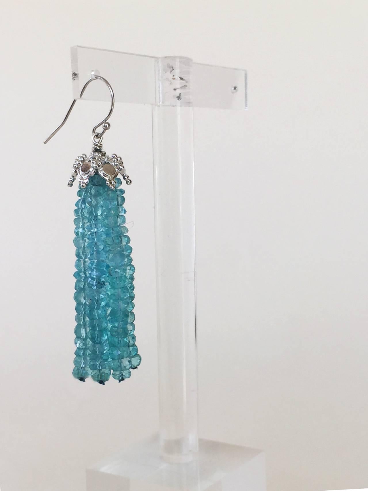 These whimsical earrings are made with graduated translucent blue topaz faceted beads. They are accented with a gracefully designed gold plated silver cups that highlights the graduated tassel. At 2.4 inches long the tassels flow beautifully in time