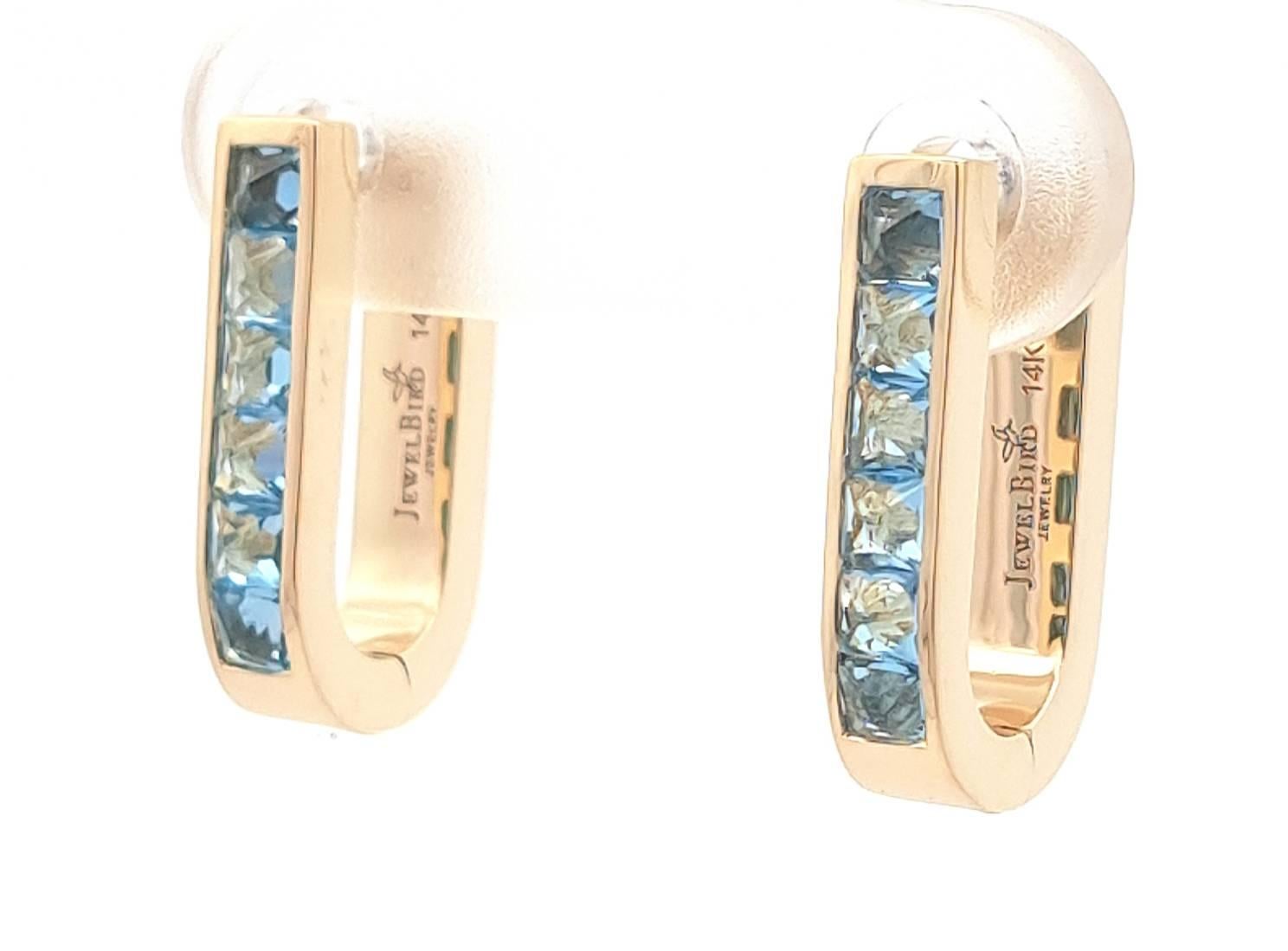 Une version moderne de la boucle d'oreille, ces superbes boucles d'oreilles en forme de U...  Ces beautés comportent 12 topazes bleues suisses de taille princesse pour un total de 0,78 ctw. Elles sont serties à l'envers, de sorte que les pointes des