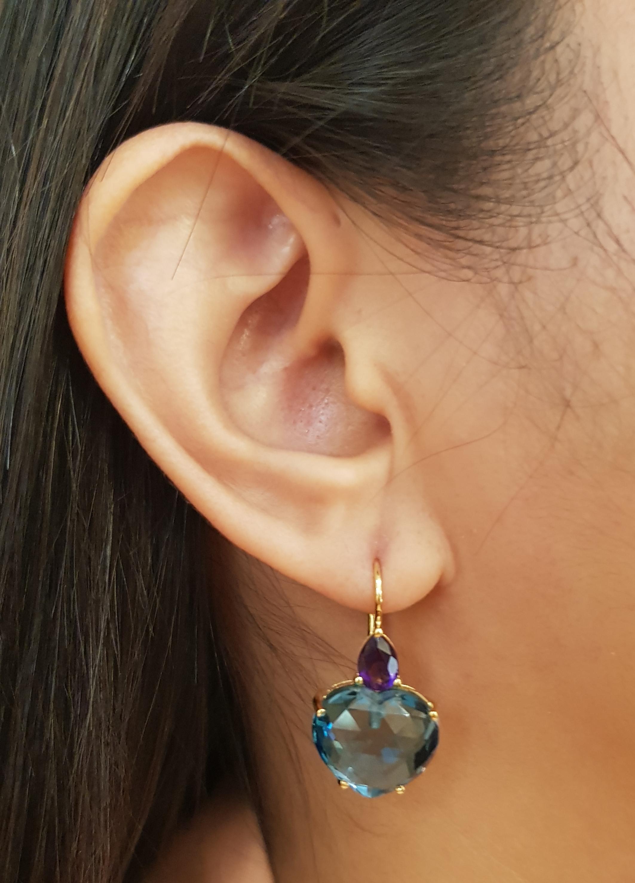 Topazio blu 24,82 carati con ametista 1,23 carati Orecchini con montatura in oro 18 carati

Larghezza: 1.5 cm 
Lunghezza: 2.7 cm
Peso totale: 10.59 grammi

