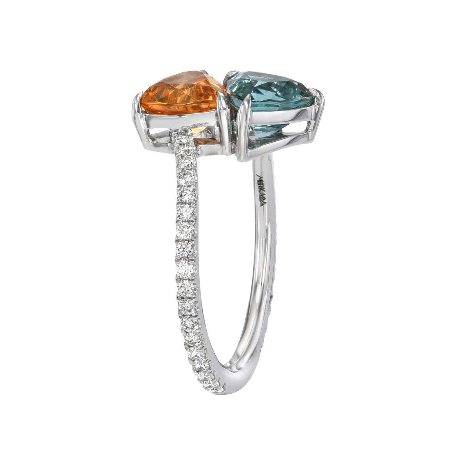 Unique and exclusive mismatched pair of 2.57 carats total Blue Tourmaline and Mandarin Garnet trillions, mounted in this spectacular bypass platinum ring, decorated with a total of 0.62 carat round brilliant collection diamonds.
Ring size 6.