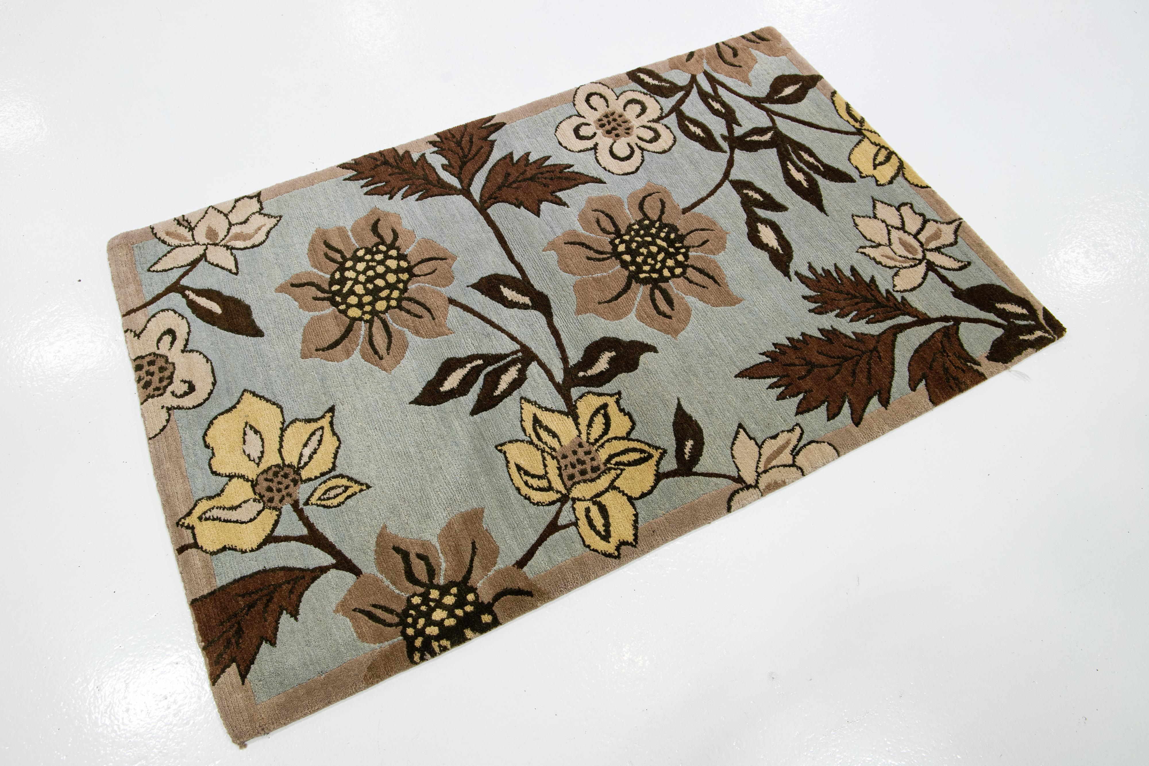 This modern custom rug features charming florals surrounded by subtle borders. It brings the garden inside with a beautiful display of autumnal colors and a sophisticated balance of brown tones over a frosty light blue field.

The price is based on
